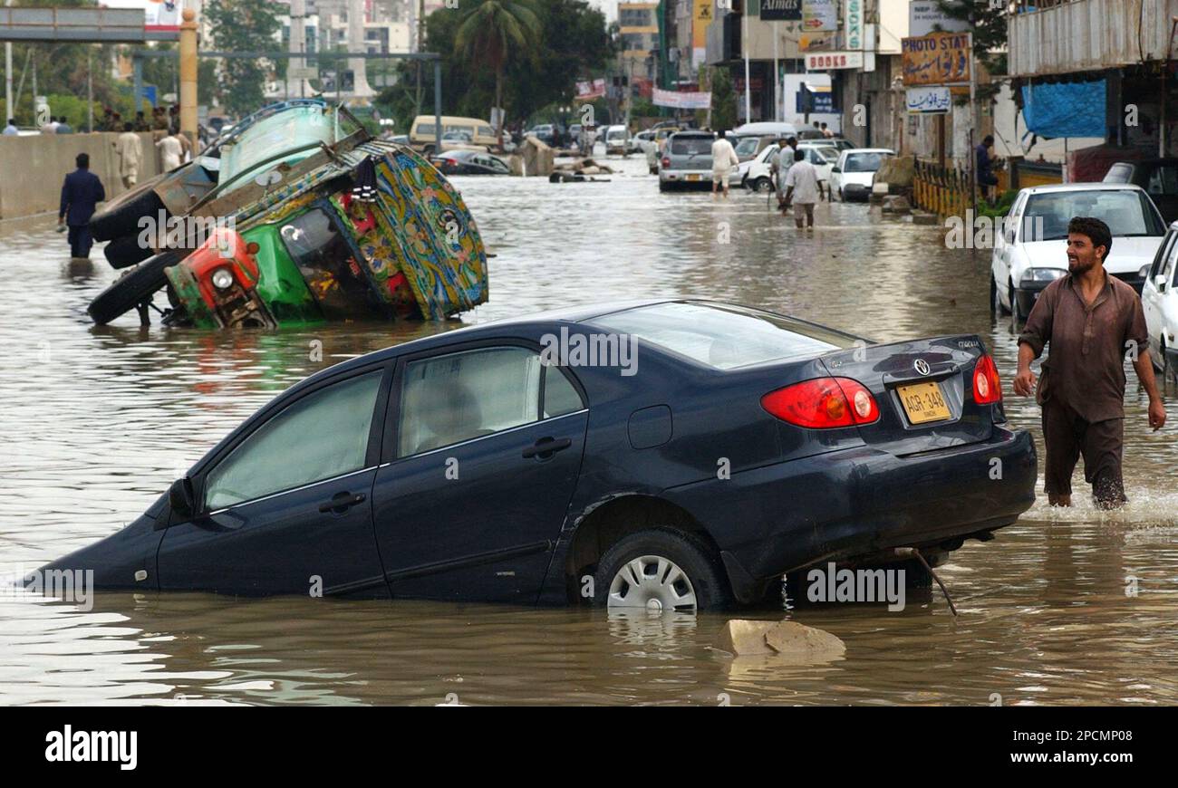 Vehicles are submerged in the rain-triggered flood water after a heavy ...