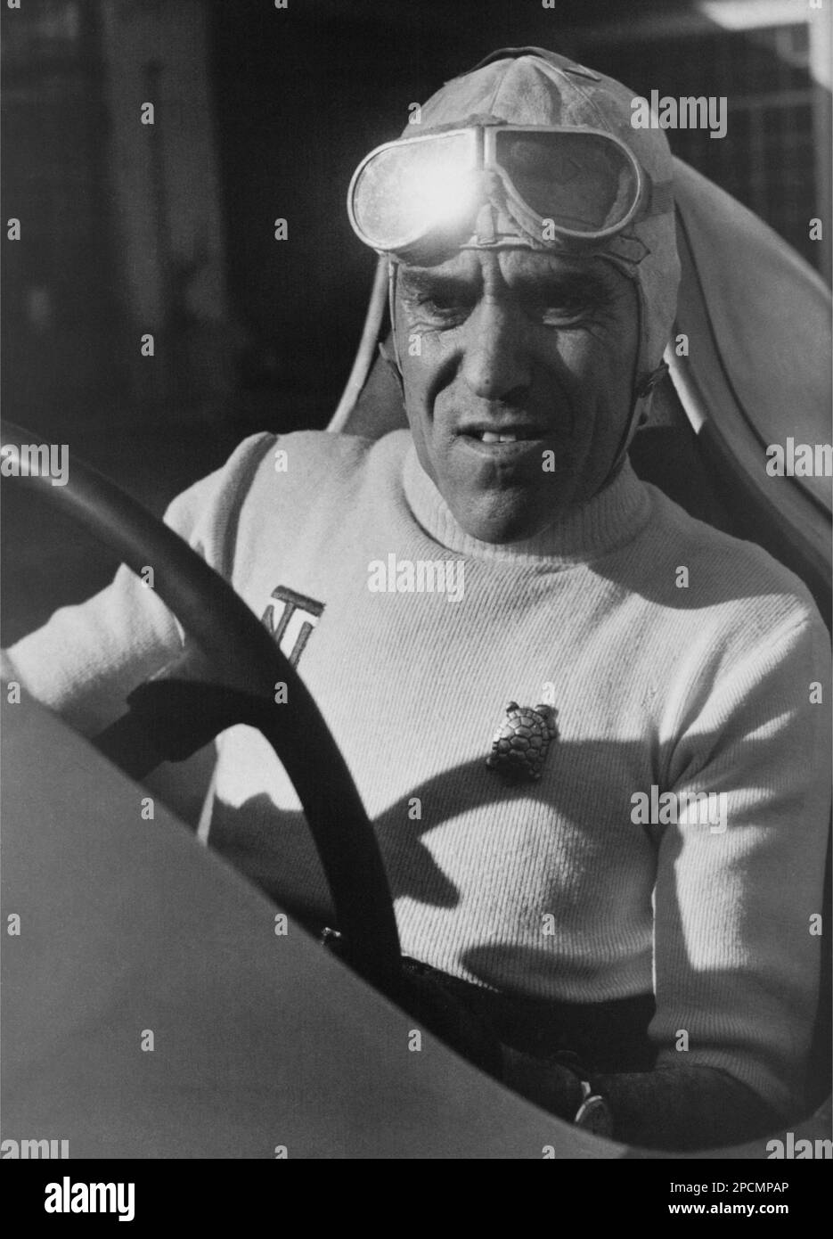 1935 ca, ITALY : Legendary italian motorcycle and racecar driver TAZIO NUVOLARI ( 1892 - 1953 ). The turtle pin on shirt was a gift by italian poet GABRIELE D'ANNUNZIO  - SPORT - AUTOMOBILISMO - gara automobilistica - AUTOMOBILE - corsa - AUTO - CAR - HISTORY PHOTO - FOTO STORICA STORICHE - Millemiglia - automobilismo - automobile - hat - cappello  - ALFA ROMEO - tuta da pilota - spilla - tartaruga - portafortuna  ----  Archivio GBB Stock Photo
