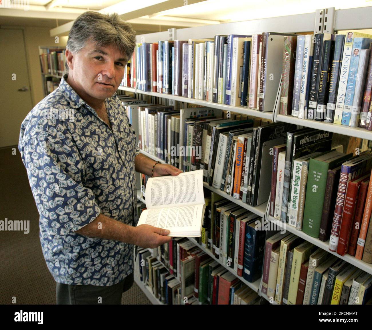 Robert Bombard scans the bookshelves at the Worcester Public Library in