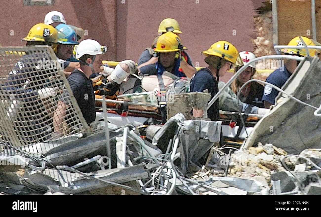 Firefighters and rescue workers rush a construction worker to a waiting ...