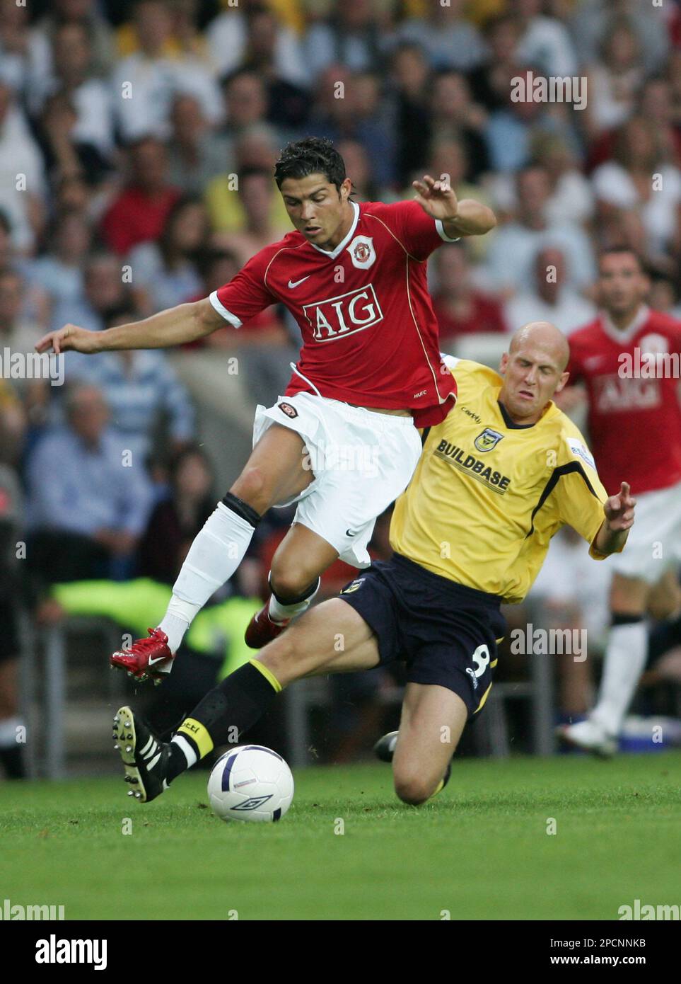 Manchester United's Cristiano Ronaldo jumps over a tackle by Oxford United  Eddie Hutchinson during their friendly pre-season soccer match at Kassam  Stadium in Oxford, England, Tuesday, Aug 8, 2006. (AP Photo/Sang Tan