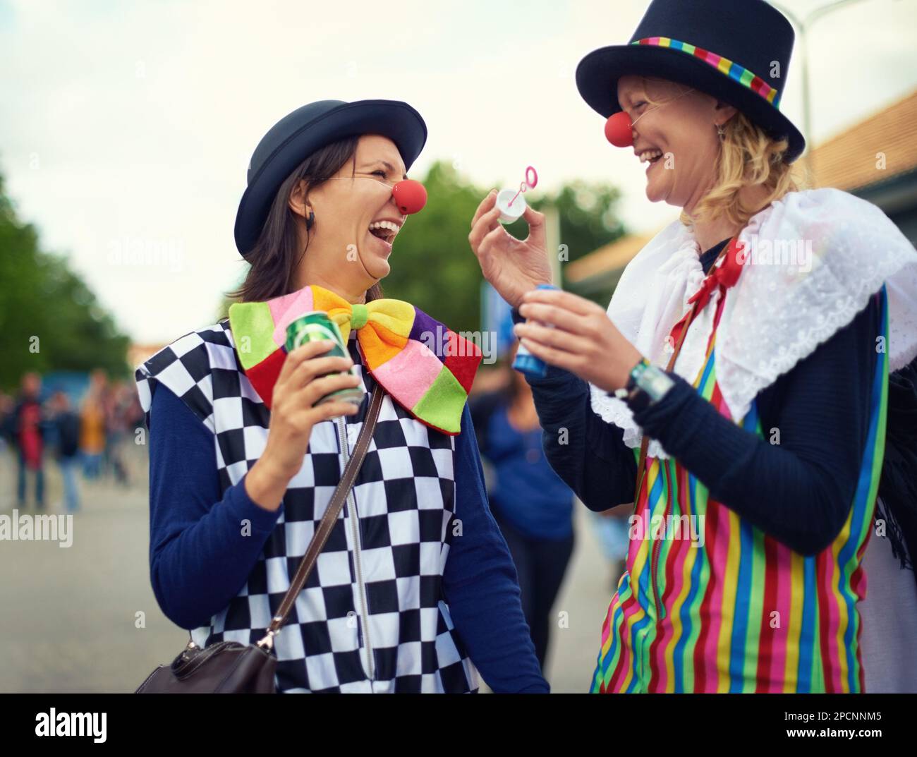 Just clowning around. two clowns blowing bubbles at an outdoor festival. Stock Photo