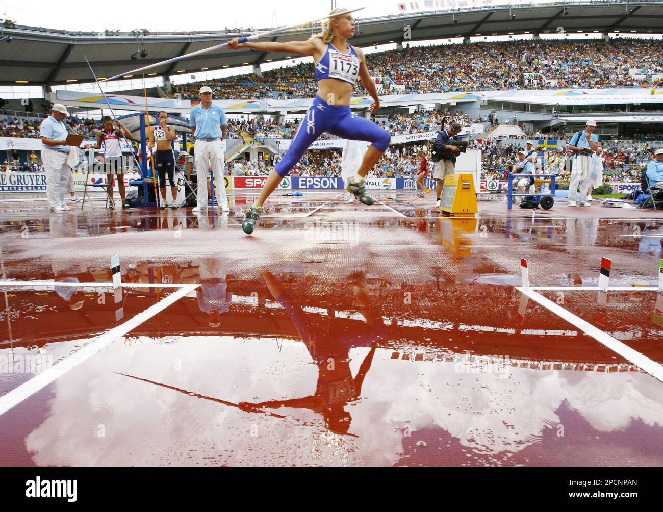 Estonia's Kaie Kand is reflected in a pool of rainwater as she competes during the Heptathlon