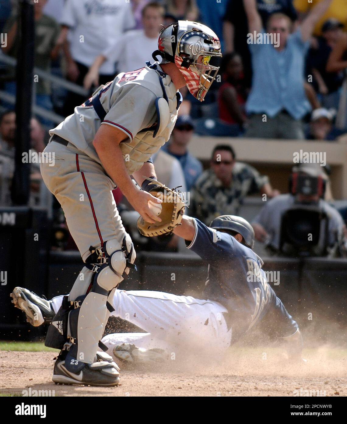 San Diego Padres' Dave Roberts, right, scores the winning run as Washington  Nationals catcher Brian Schneider catches the ball too late for the tag in  the 10th inning of a baseball game