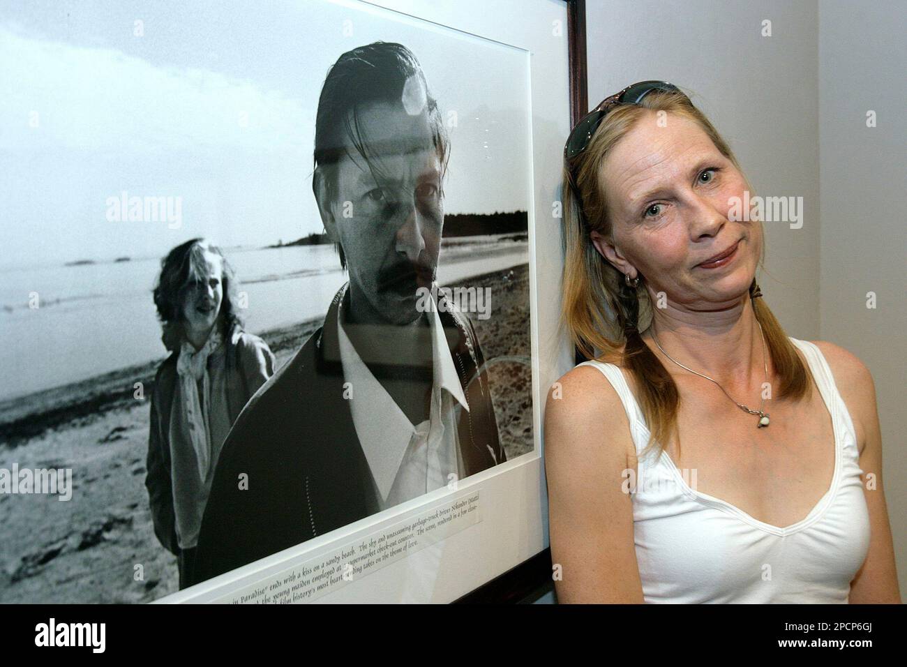 Finnish actress Kati Outinen poses next to a photograph showing her together with actor Matti Pellonpaeae on the set of Aki Kaurismaeki's "Shadows in Paradise" (1986), during the inauguration of the photo exhibition "Shadows in Paradise", at the 59th International Film Festival Locarno, Thursday, August 3, 2006, in Locarno, Switzerland. To accompany the Aki Kaurismaeki Retrospective at the film festival, an exhibition of photographs by Marja-Leena Hukkanen, who followed the work of the Finnish filmmaker on set, is shown at Casa Rusca in Locarno. (KEYSTONE/Martial Trezzini) Stock Photo