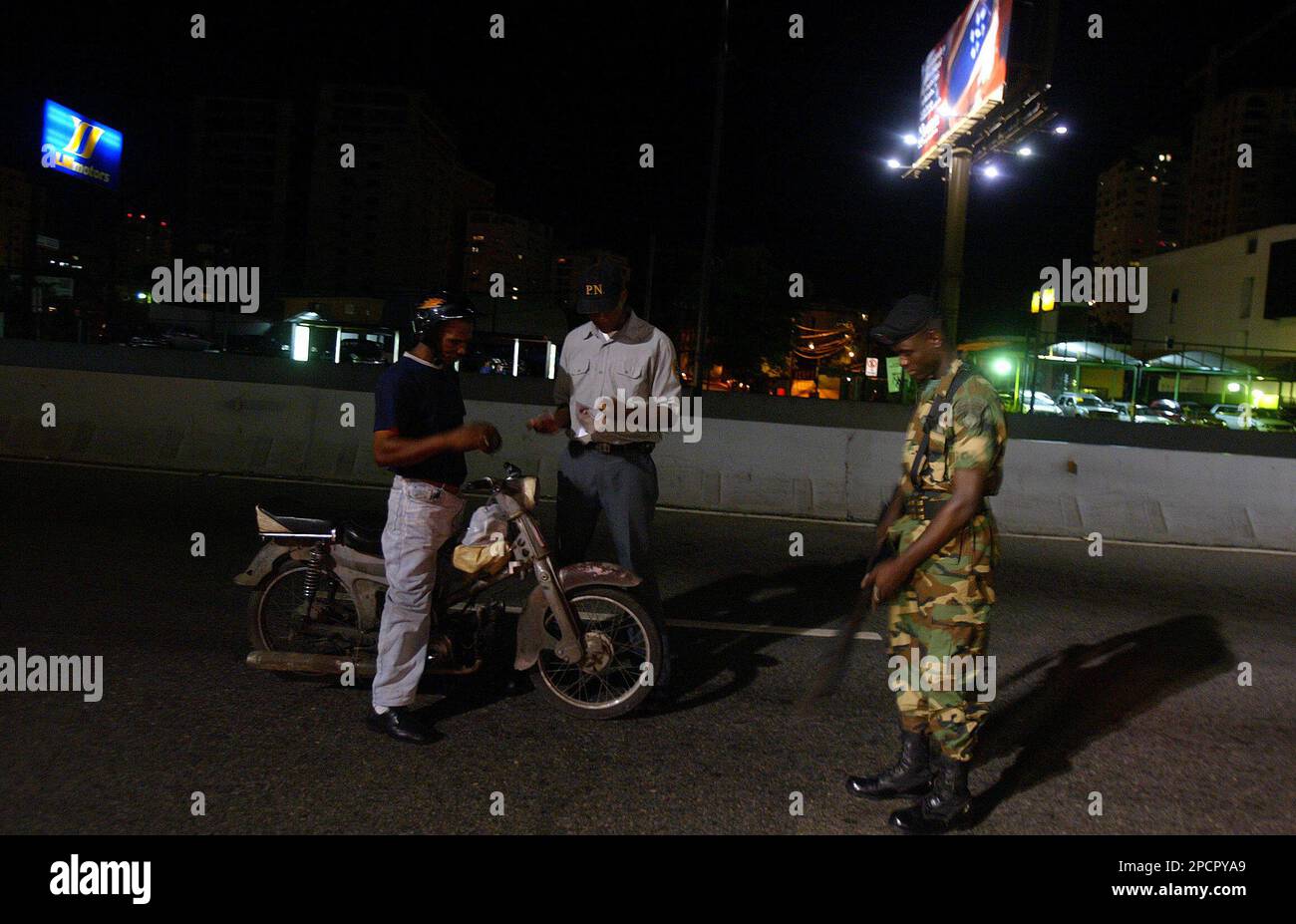 A Dominican soldier watches while a national police officer registers a