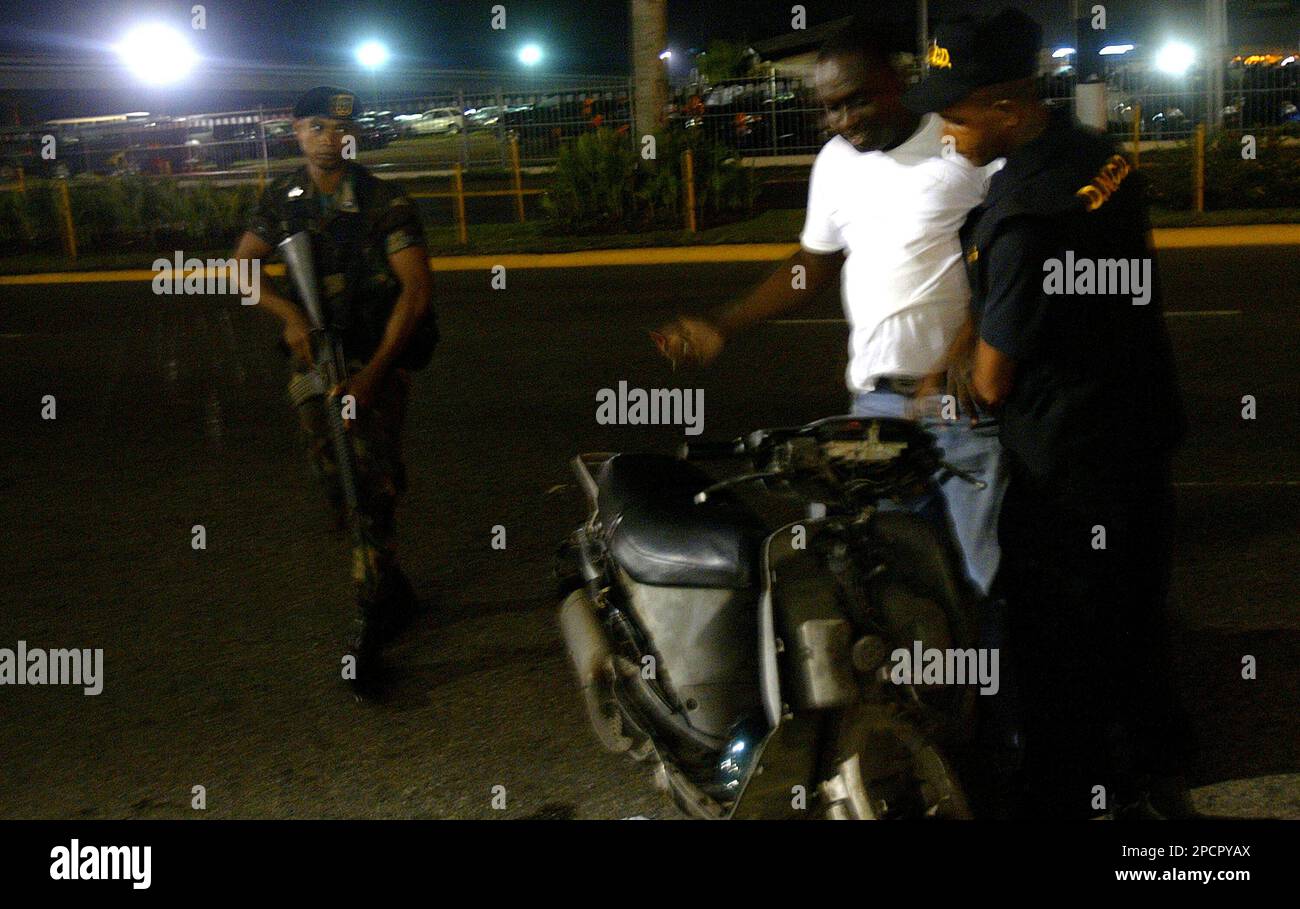 A Dominican soldier watches while a national police officer registers a citizen during the