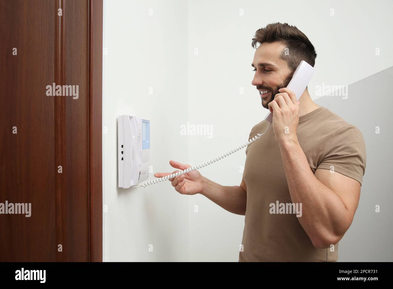 Man with handset answering call indoors Stock Photo Alamy