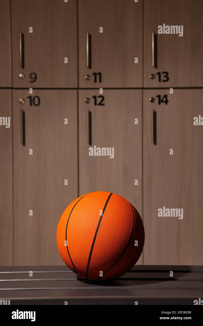 Orange basketball ball on wooden bench in locker room Stock Photo Alamy