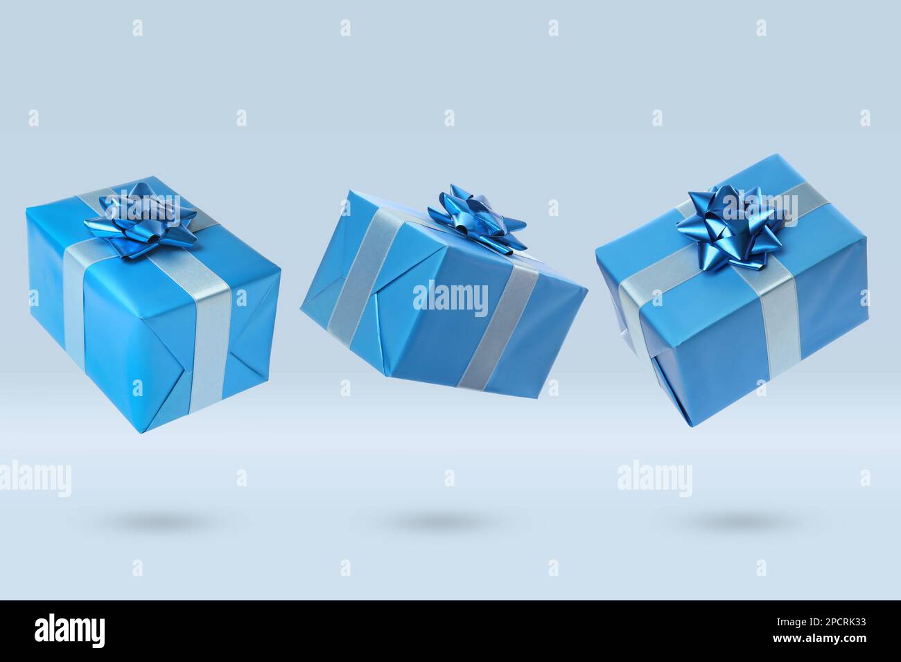 Beautifully wrapped gift boxes flying on light background Stock Photo