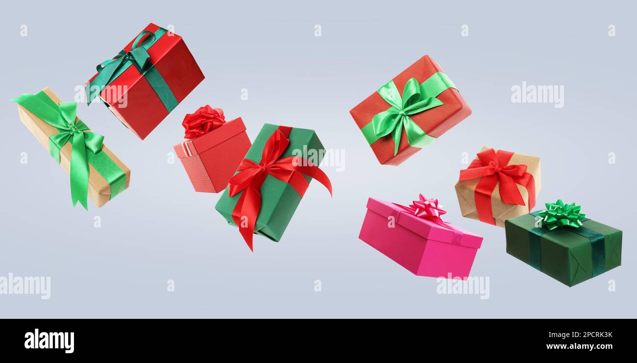 Beautifully wrapped gift boxes flying on light background Stock Photo