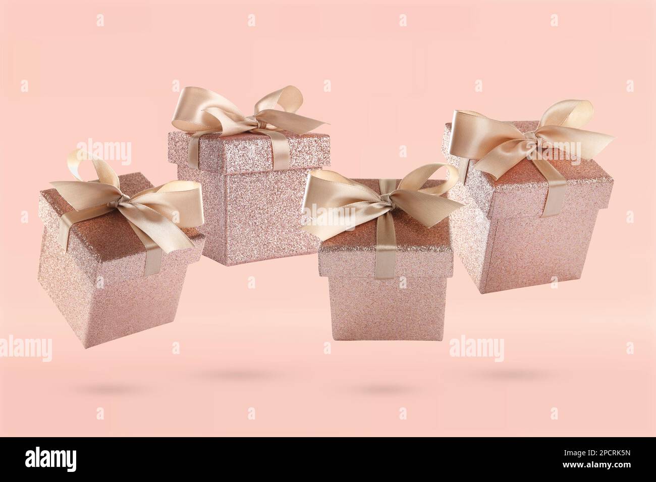 Beautifully wrapped gift boxes flying on pink background Stock Photo