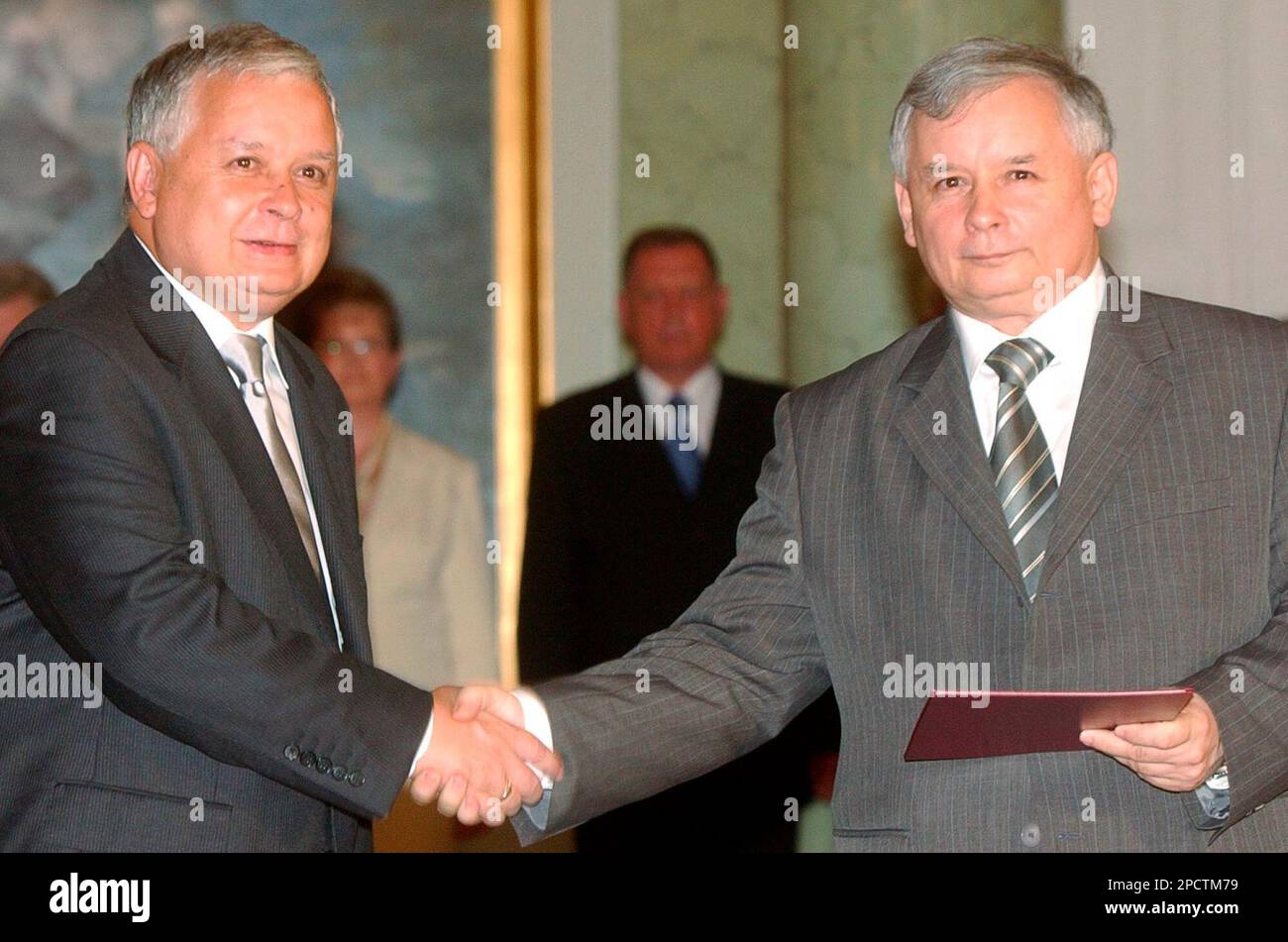 Polish President Lech Kaczynski, left, shakes hands with his twin brother Jaroslaw Kaczynski, after naming him Poland's new Prime Minister, in Warsaw, Poland, Monday, July 10, 2006. Jaroslaw Kaczynski, leader of the ruling Law and Justice party took the prime minister's office after Kazimierz Marcinkiewicz resigned. (AP Photo/Alik Keplicz) Stock Photo
