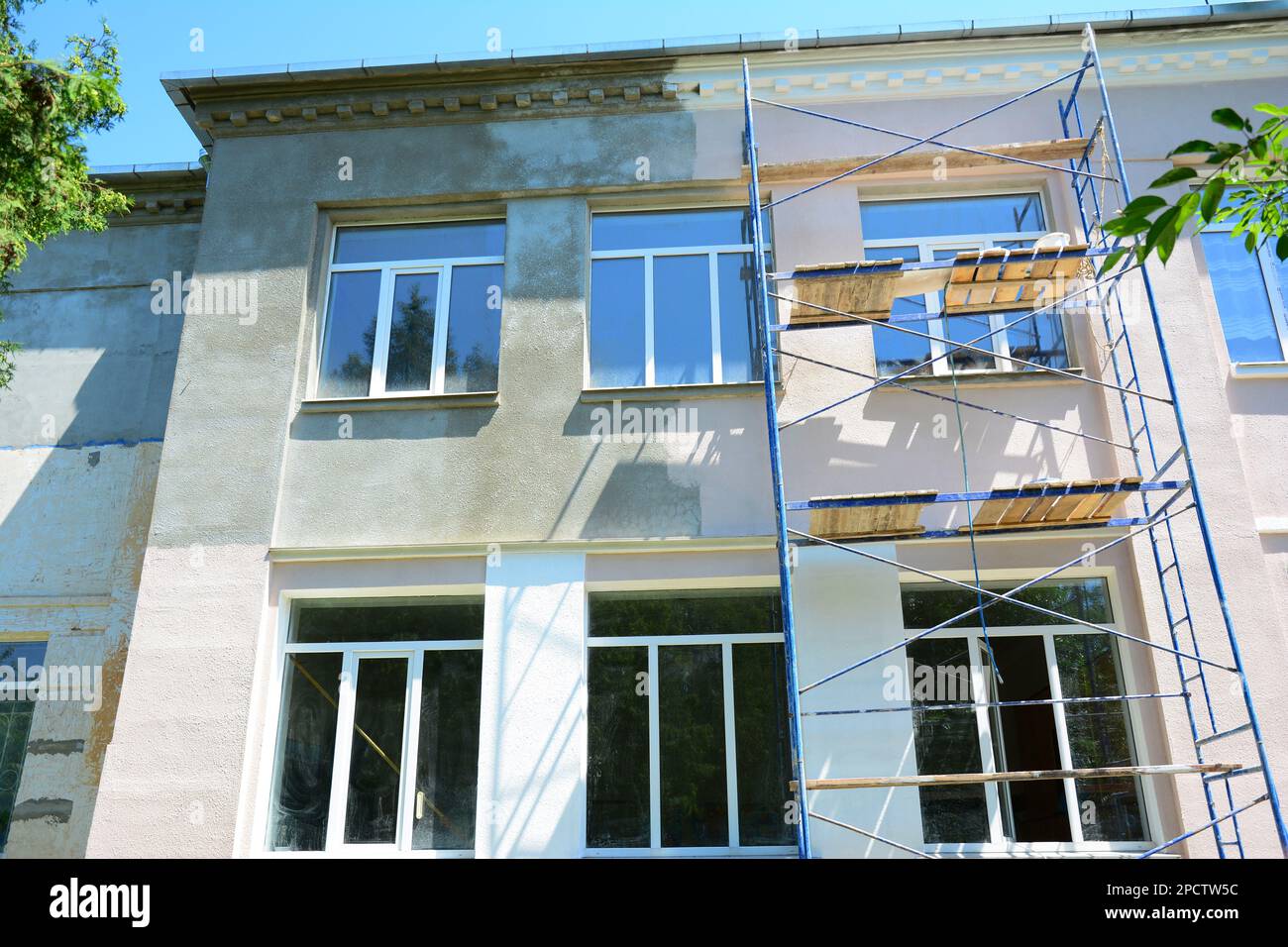 Painting house facade wall outdoors. Painting plastering exterior walls