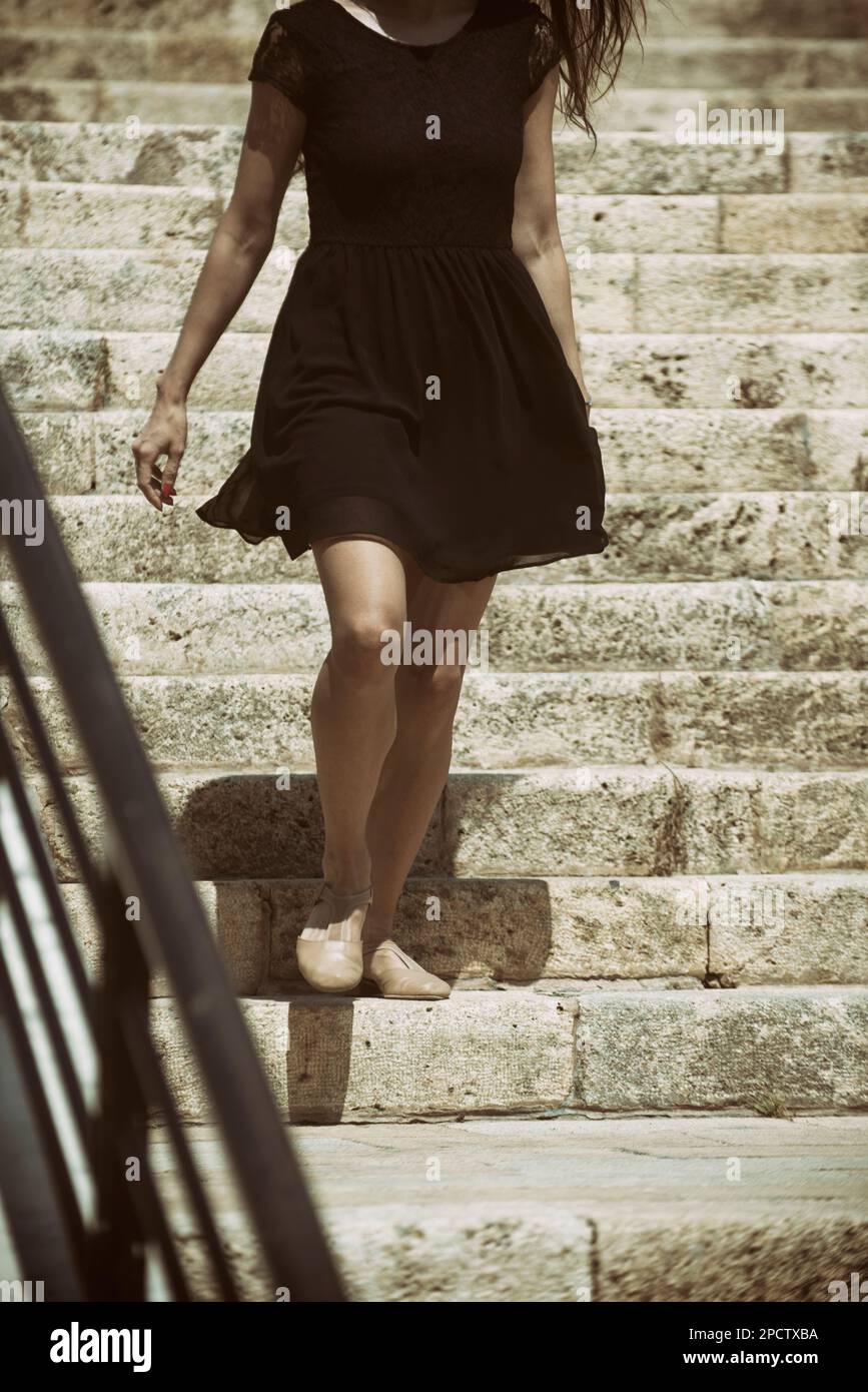 Woman walking down the stairs outdoors Stock Photo