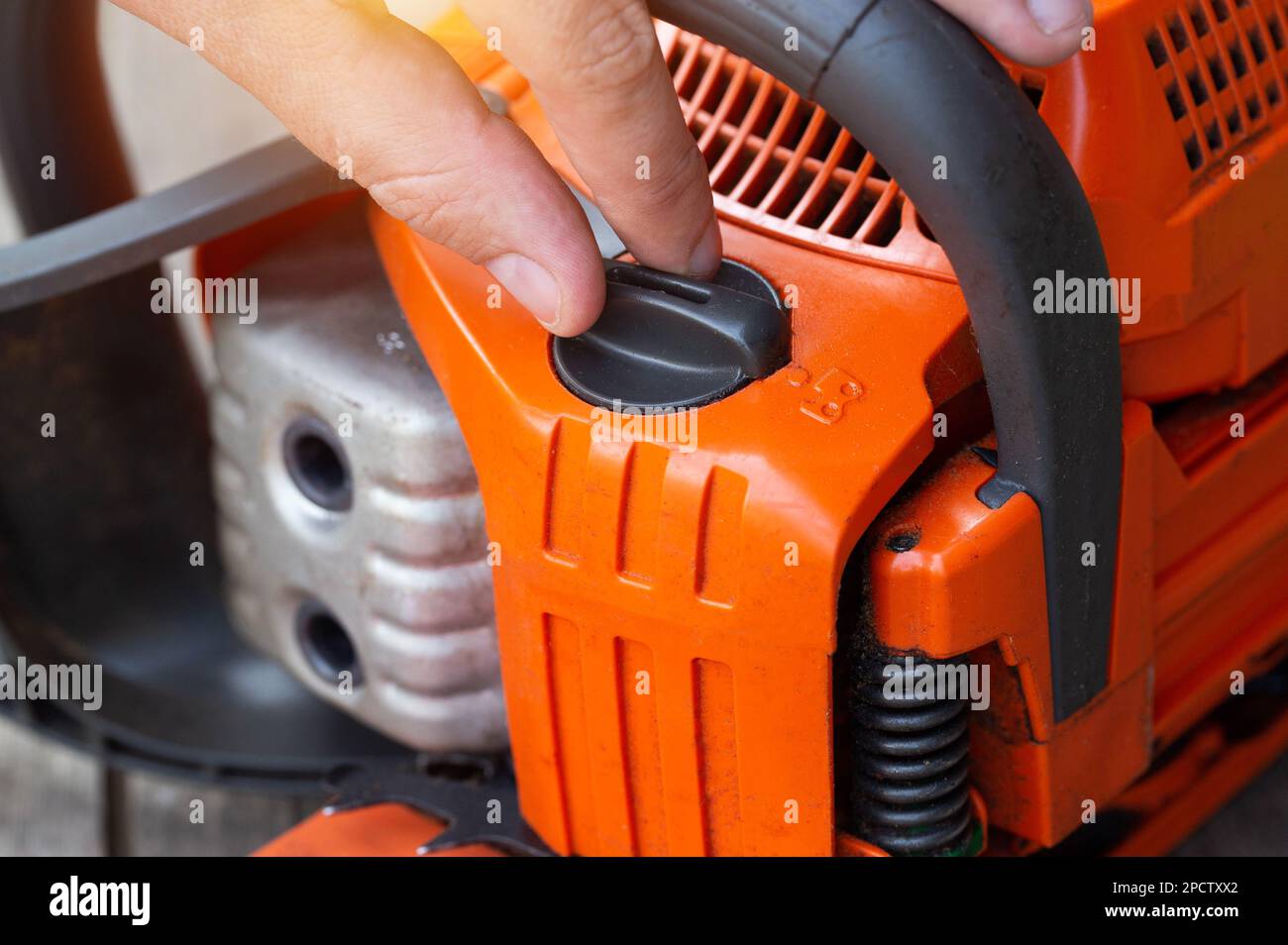 Refueling the chainsaw with chain oil Stock Photo Alamy