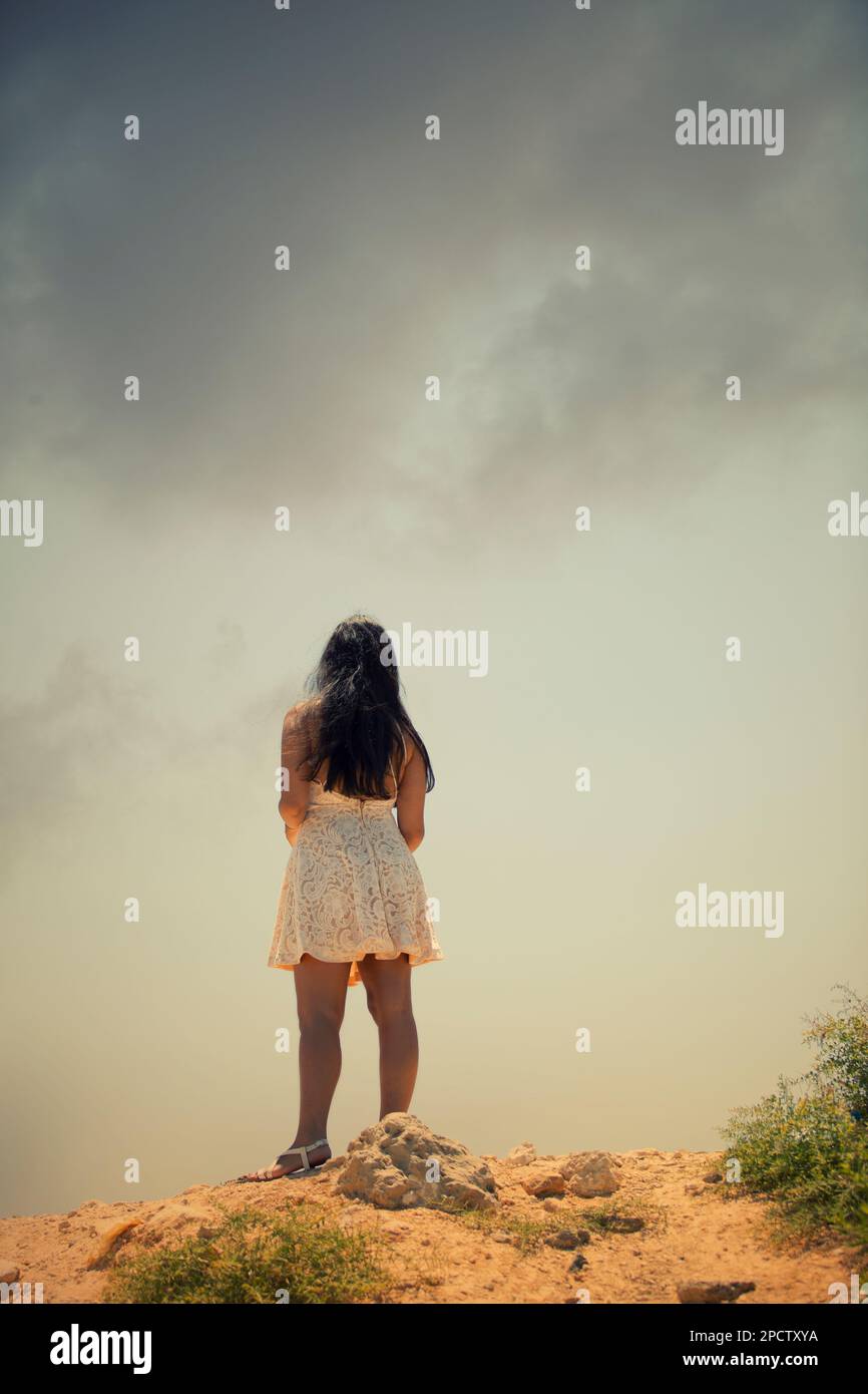 Rear view of woman wearing short white dress standing outdoors Stock ...