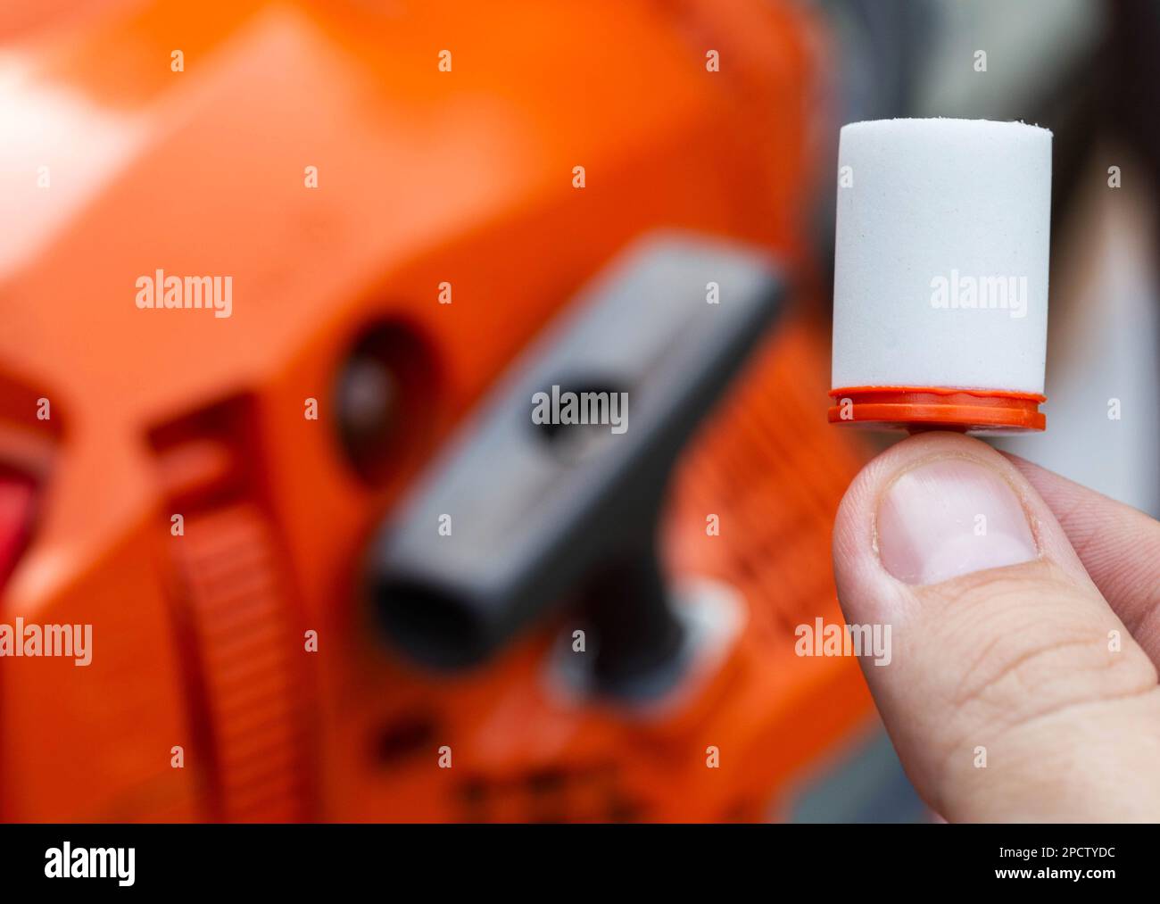 New fuel filter on the background of a chainsaw. The concept of replacing the fuel filter and