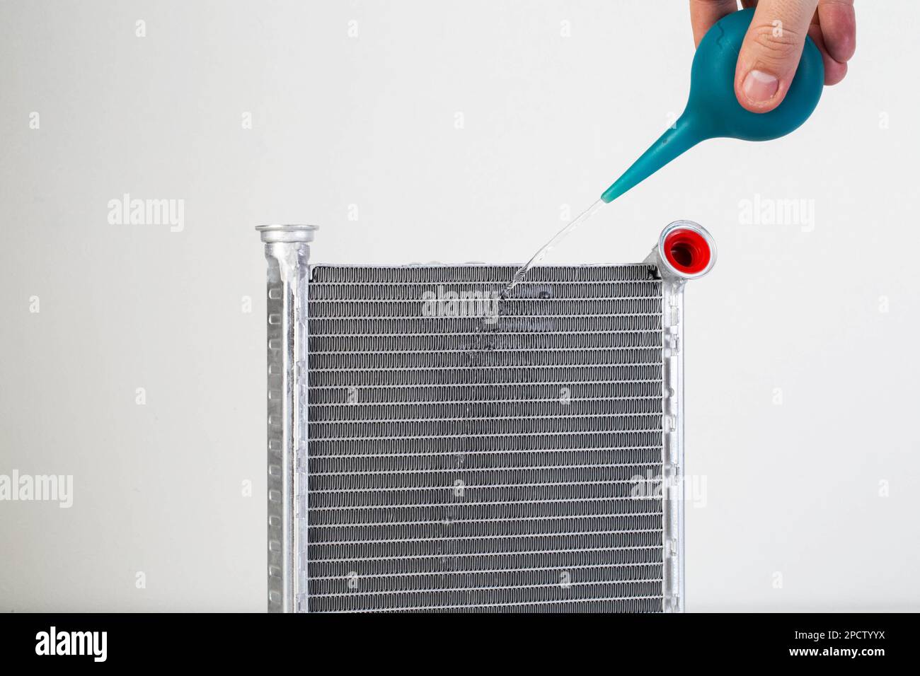 A jet of water from a syringe pours onto a car radiator. The concept of