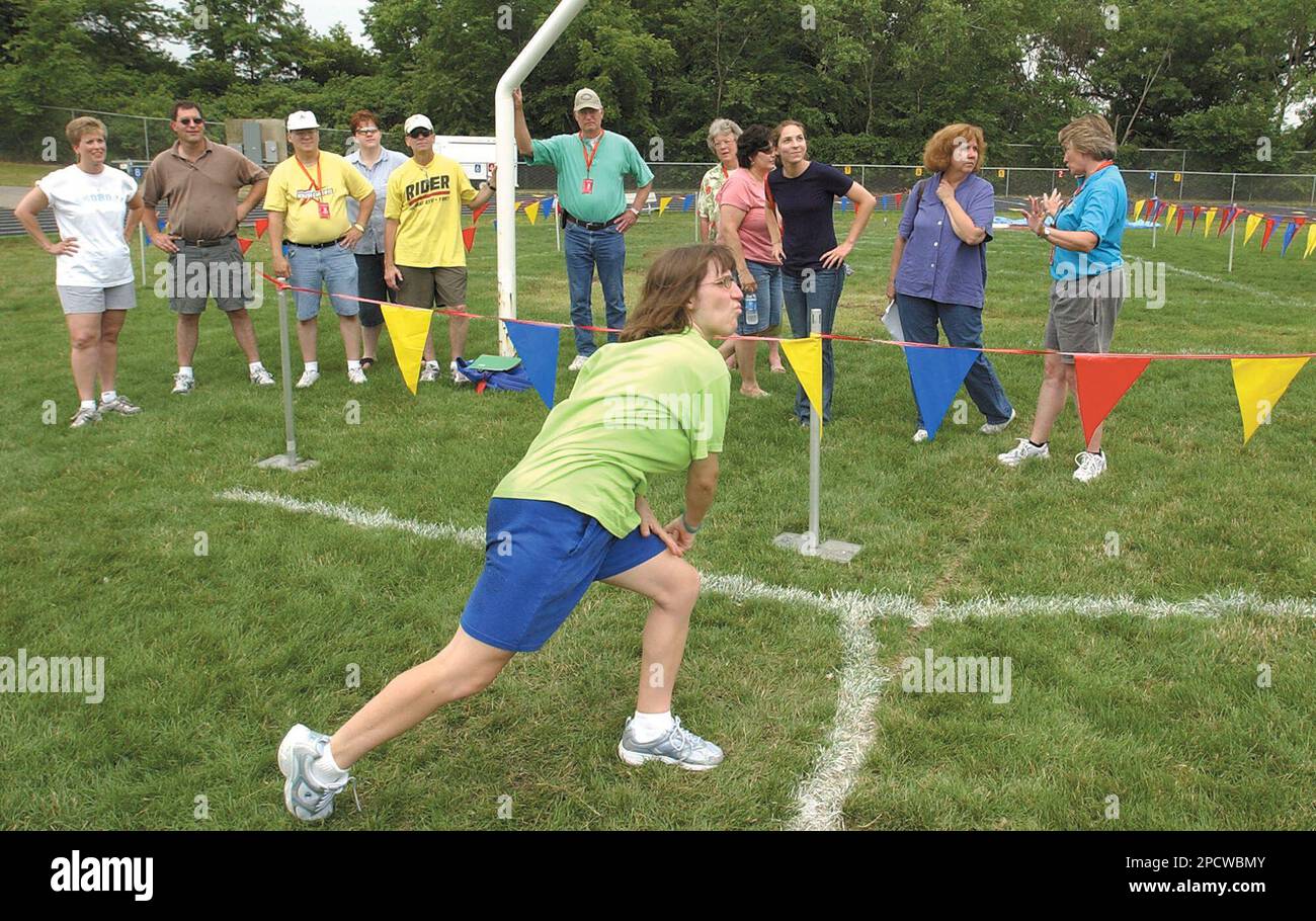 Volunteer track officials watch Shannon Murphy, a Special Olympics