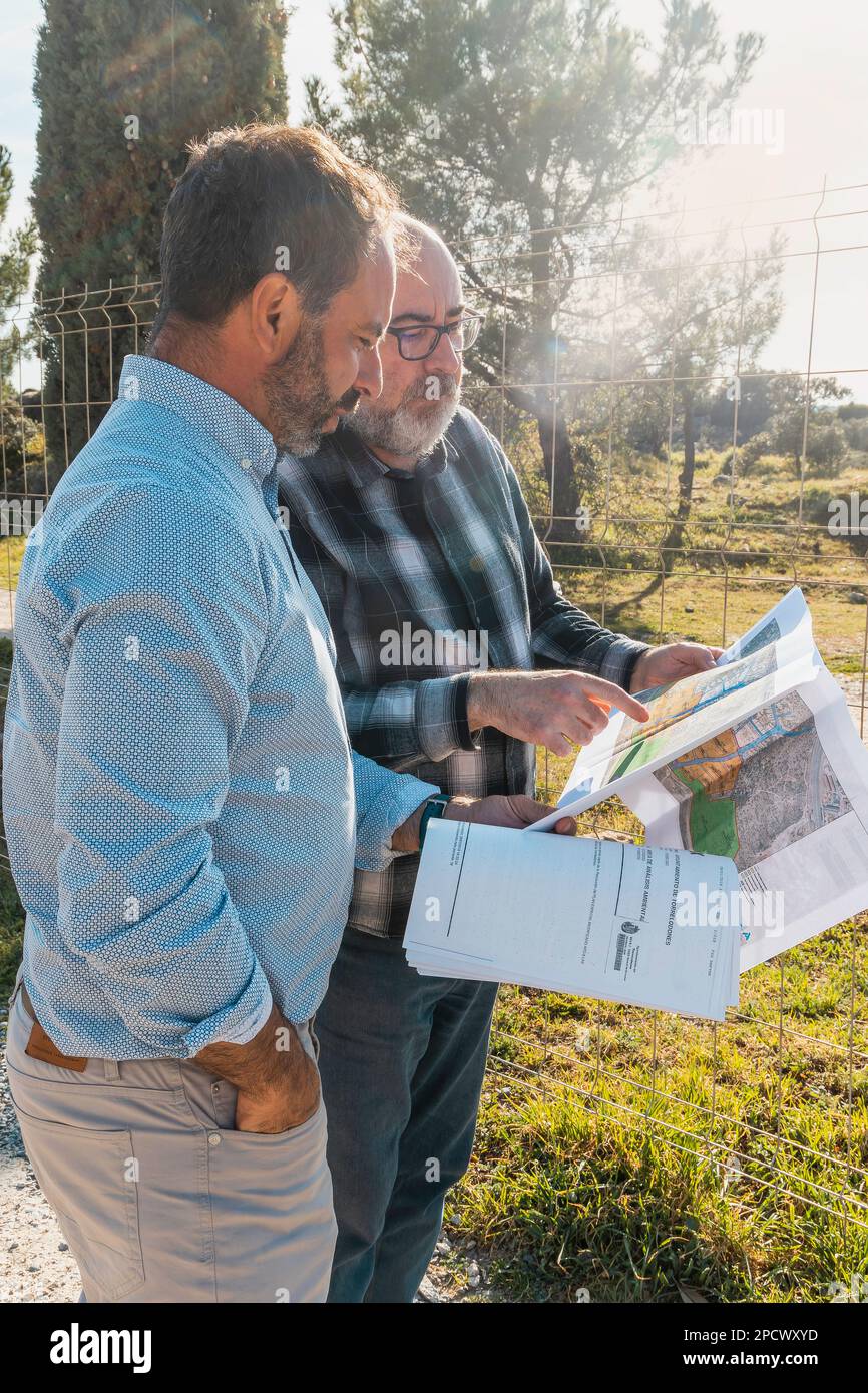 two men standing next to each other looking at documents. Teamwork concept Stock Photo