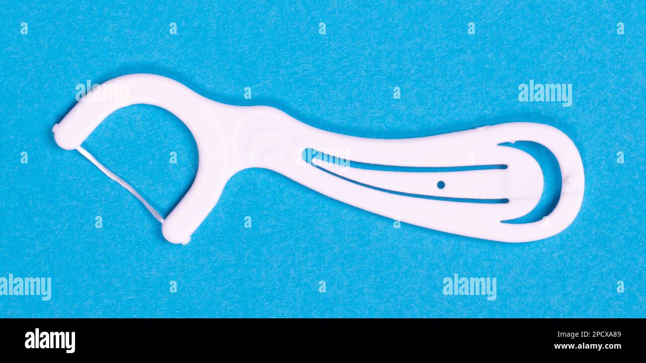 White toothpick with floss isolated with clipping path over blue ...