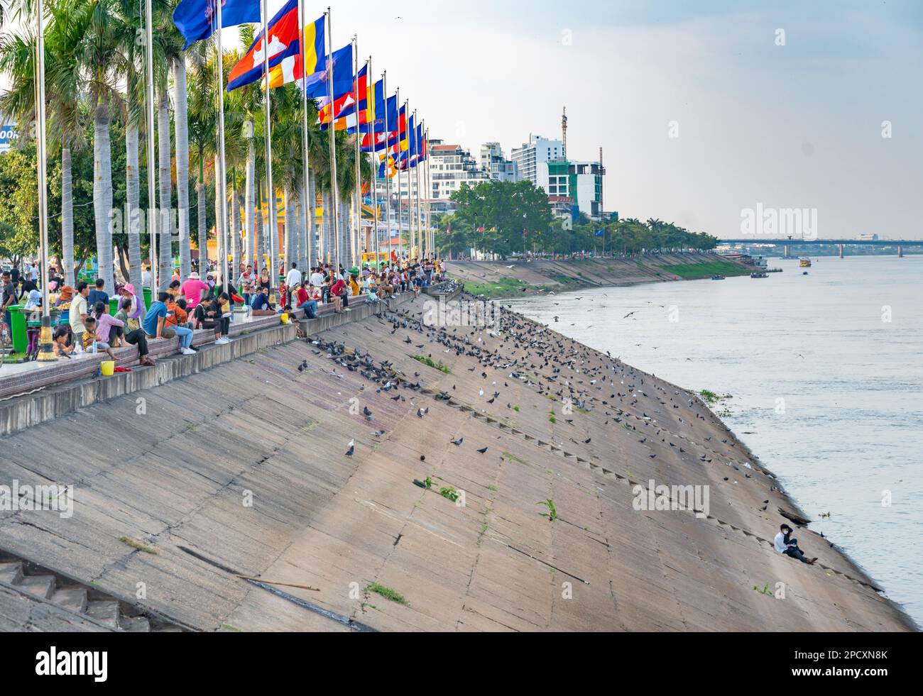 Phnom Penh,Cambodia-December 23 2023: The flag lined Riverside Path,is a popular place for Cambodian families to to come to relax,eat,pray and sociali Stock Photo