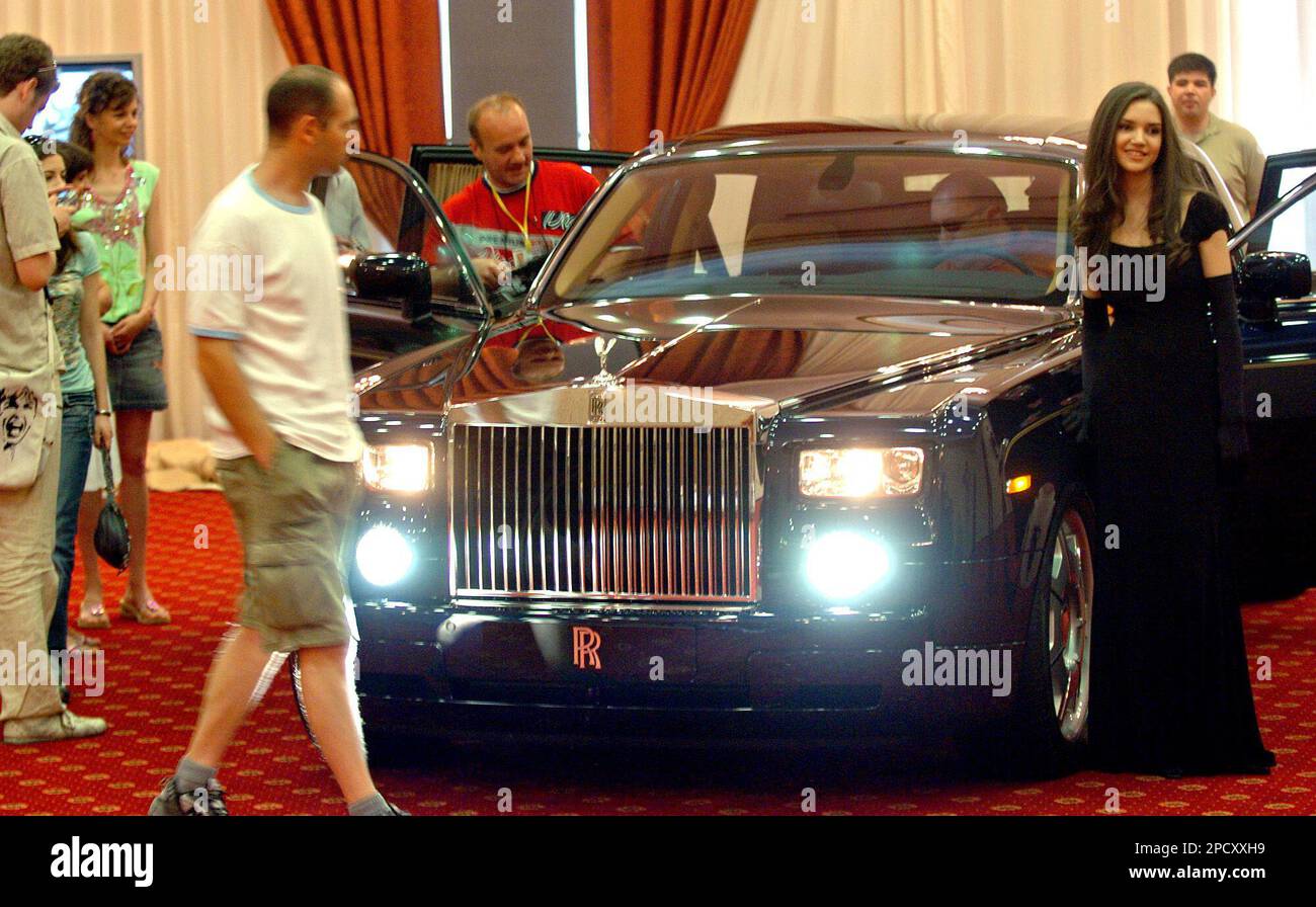 Macedonian journalists review a displayed Rolls Royce vehicle in