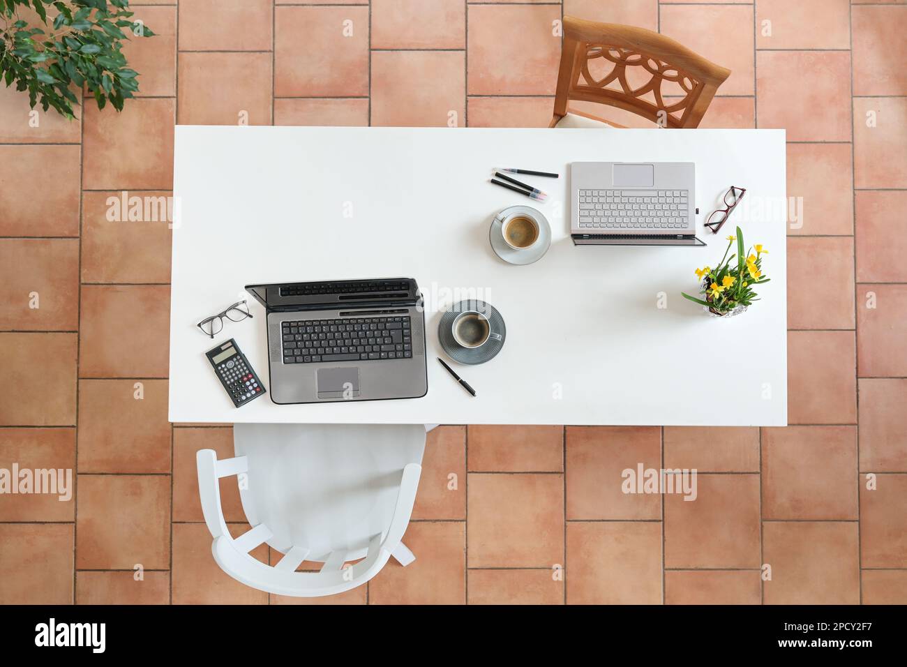 Office workplace for two in feminine and masculine style on a large white desk with laptops, coffee and chairs, top view from above, copy space, selec Stock Photo