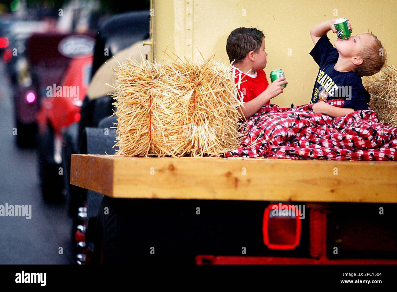 Cody Feller finishes off a soda as he rides in the back of flatbed