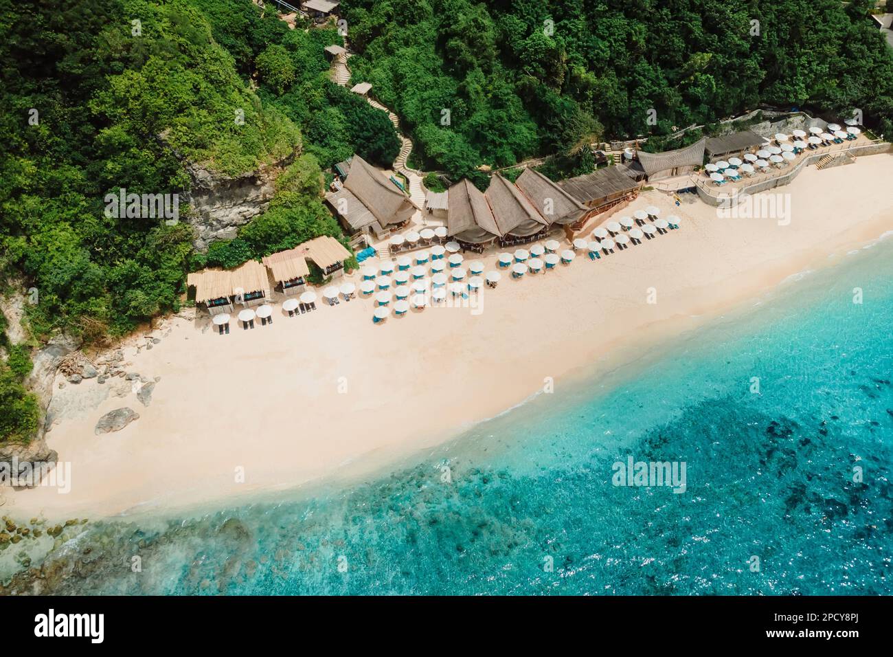 Aerial view of blue ocean and luxury beach resort with umbrellas in Bali Stock Photo