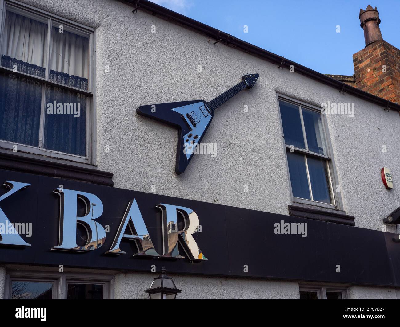 Replica Gibson Flying V guitar above a sign for a bar in Northampton