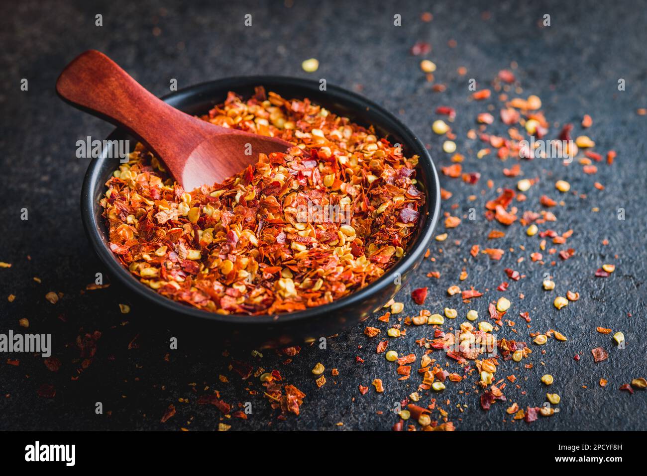 Dry chili pepper flakes. Crushed red peppers in bowl on the black table Stock Photo Alamy