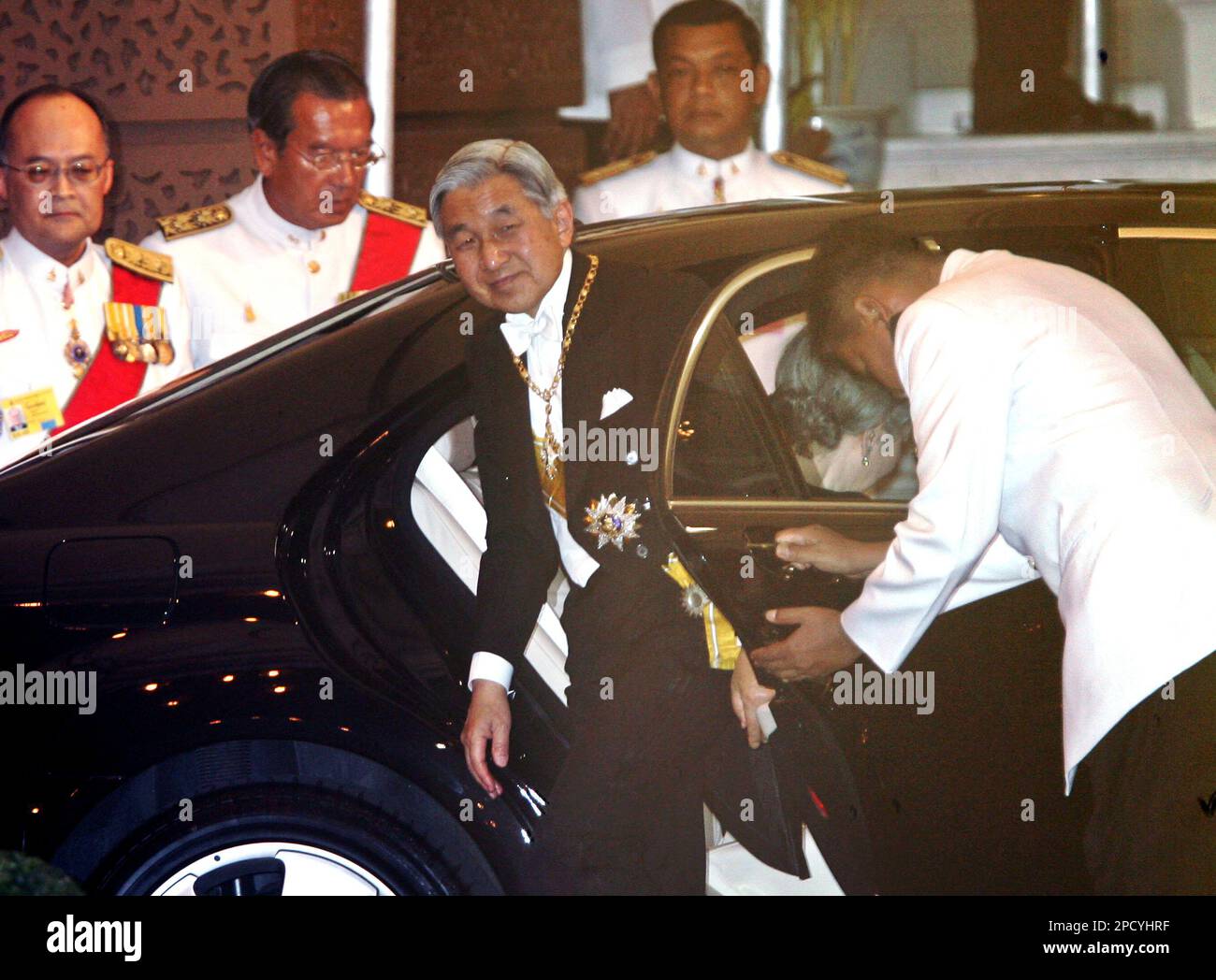 Japanese Emperor Akihito gets out of a limousine as he arrives at the Grand Palace for a banquet