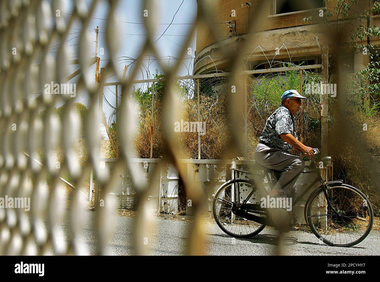 An elderly man cycles as he cross into the UN buffer zone Green
