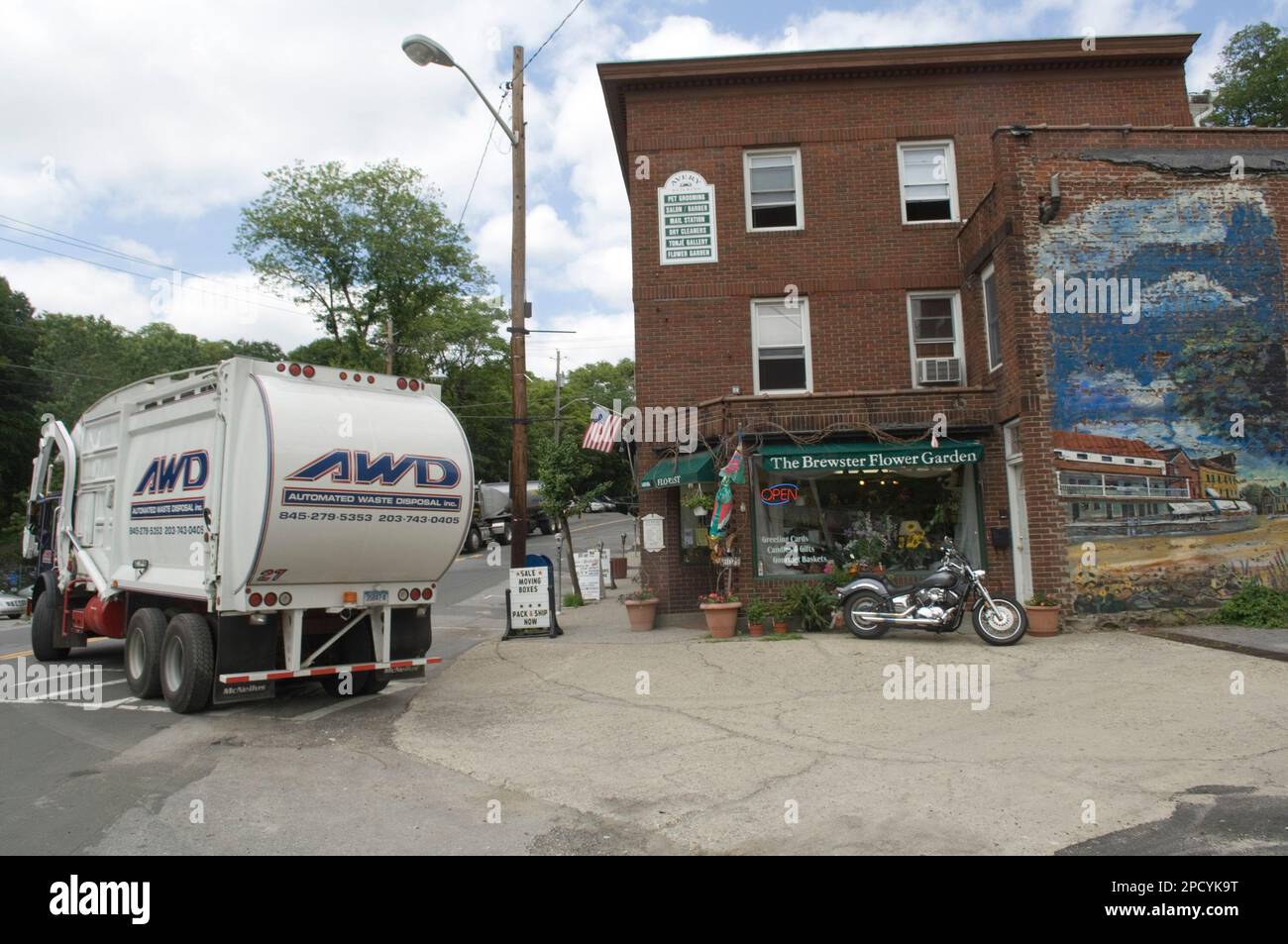 An Automated Waste Disposal truck turns onto Main Street in Brewster, N