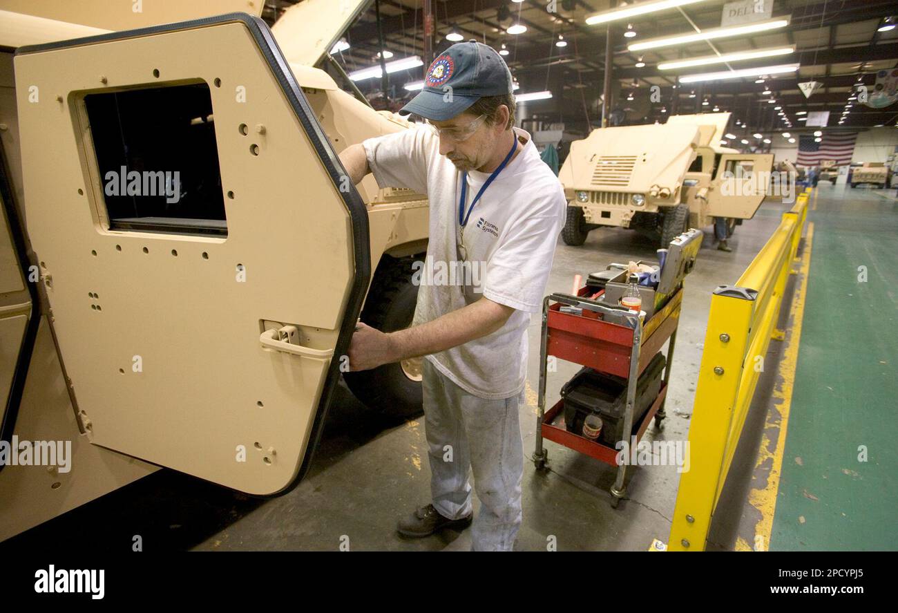 Guy Eisenmann checks the door latch mechanism on a armored Humvee at
