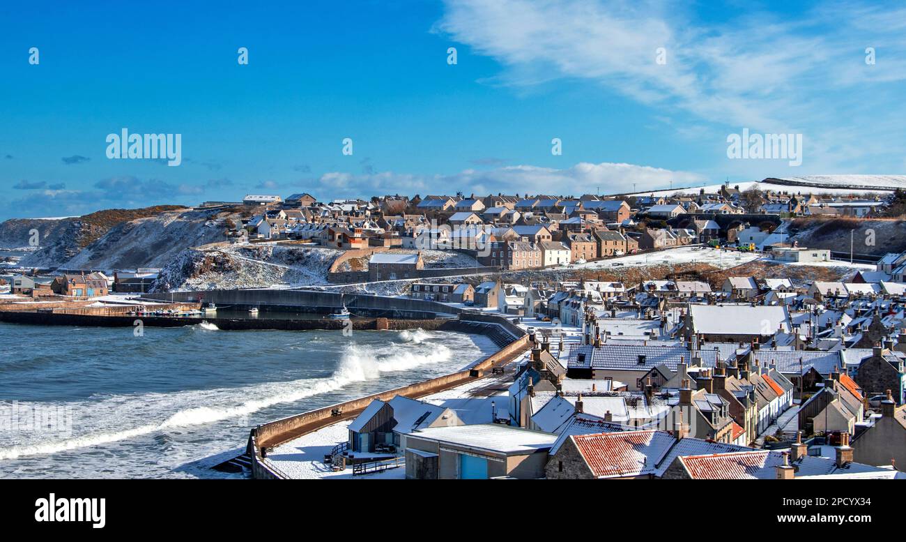 Cullen Bay Moray Scotland blue sky snow covered houses and waves