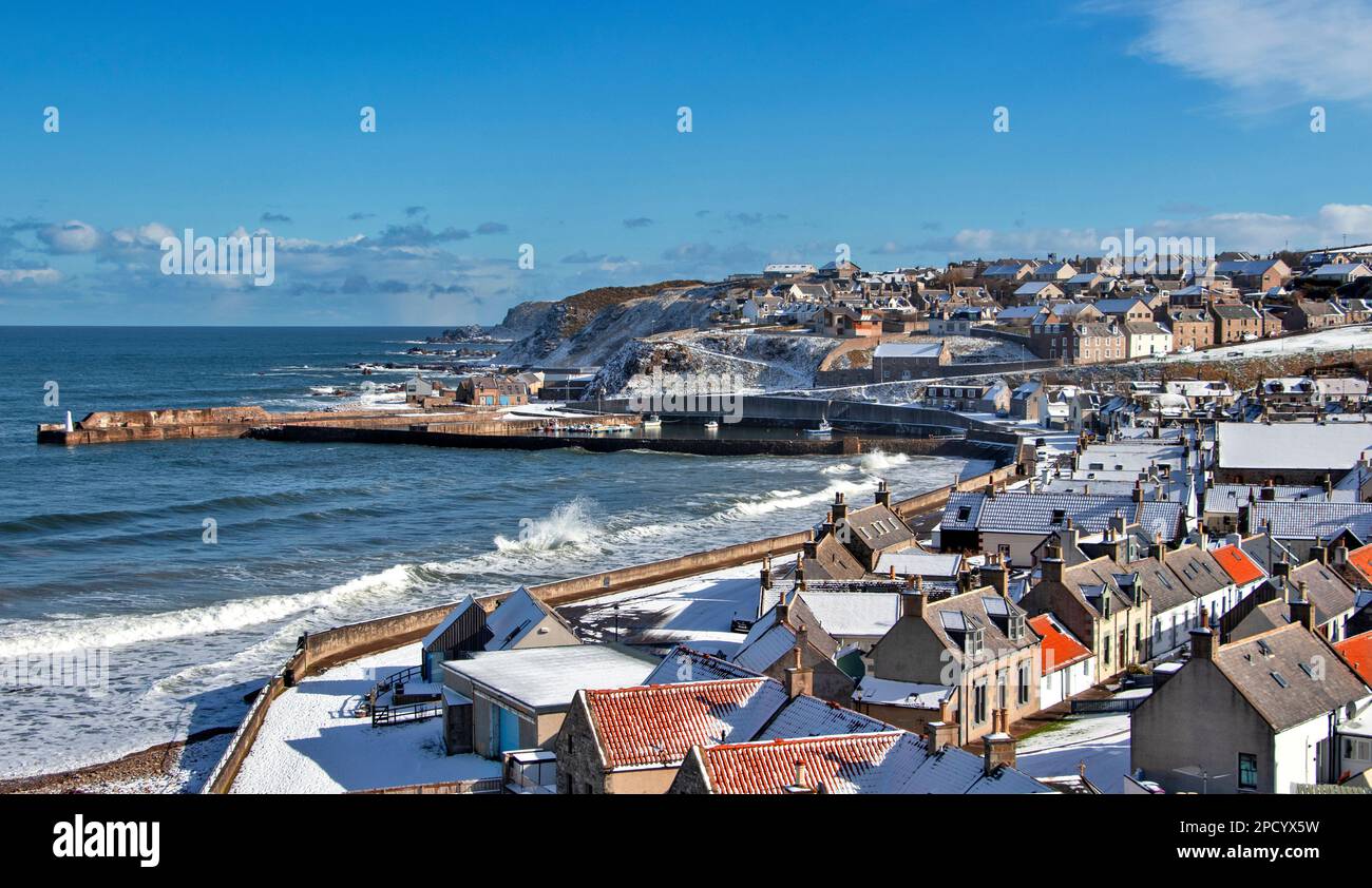 Cullen Bay Moray Scotland blue sky snow covered houses and waves