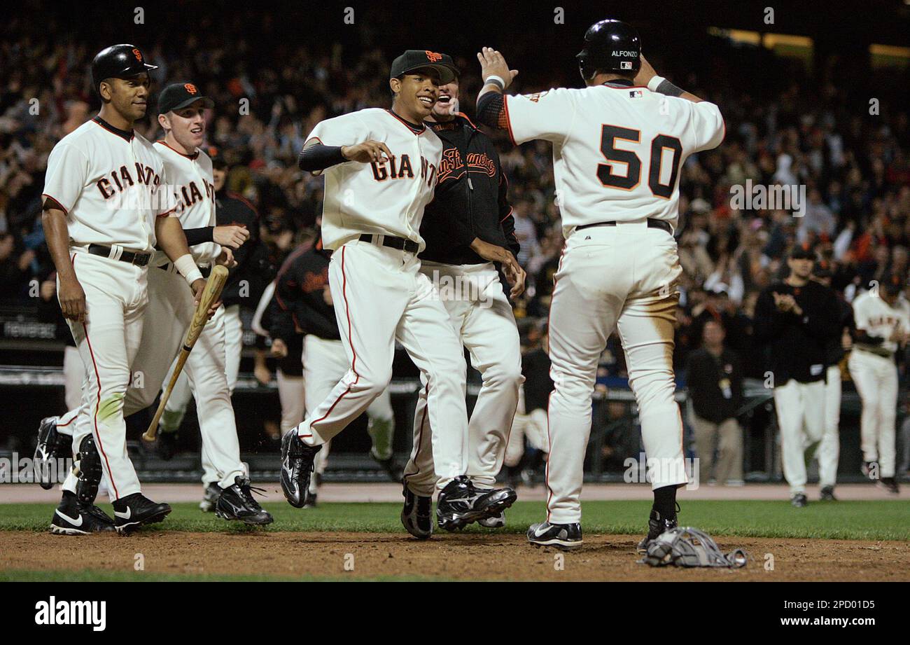 San Francisco Giants' Eliezer Alfonzo (50) is greeted by Barry Bonds