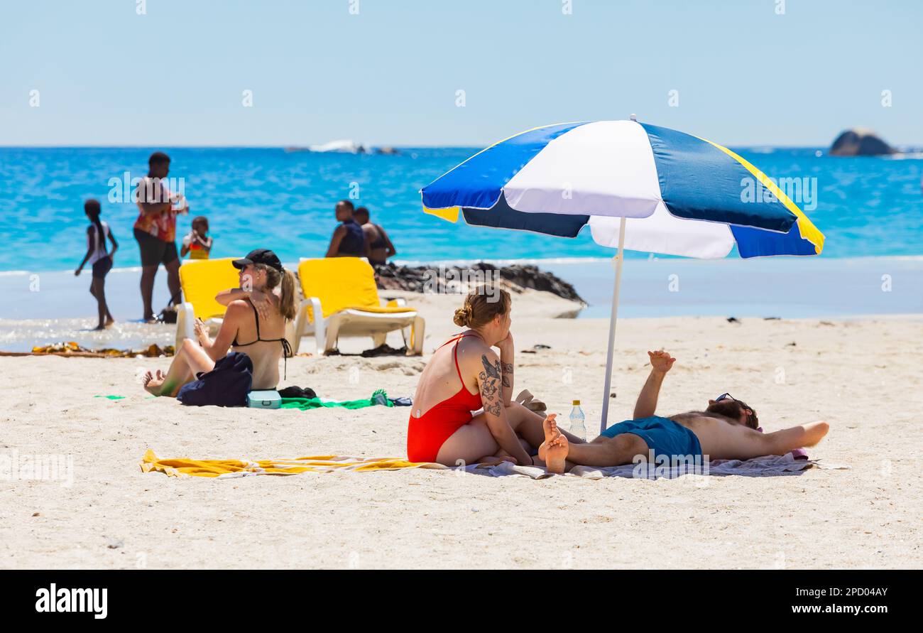 Cape Town, South Africa - February 19, 2023: View of vacationers on Camps Bay beach Stock Photo