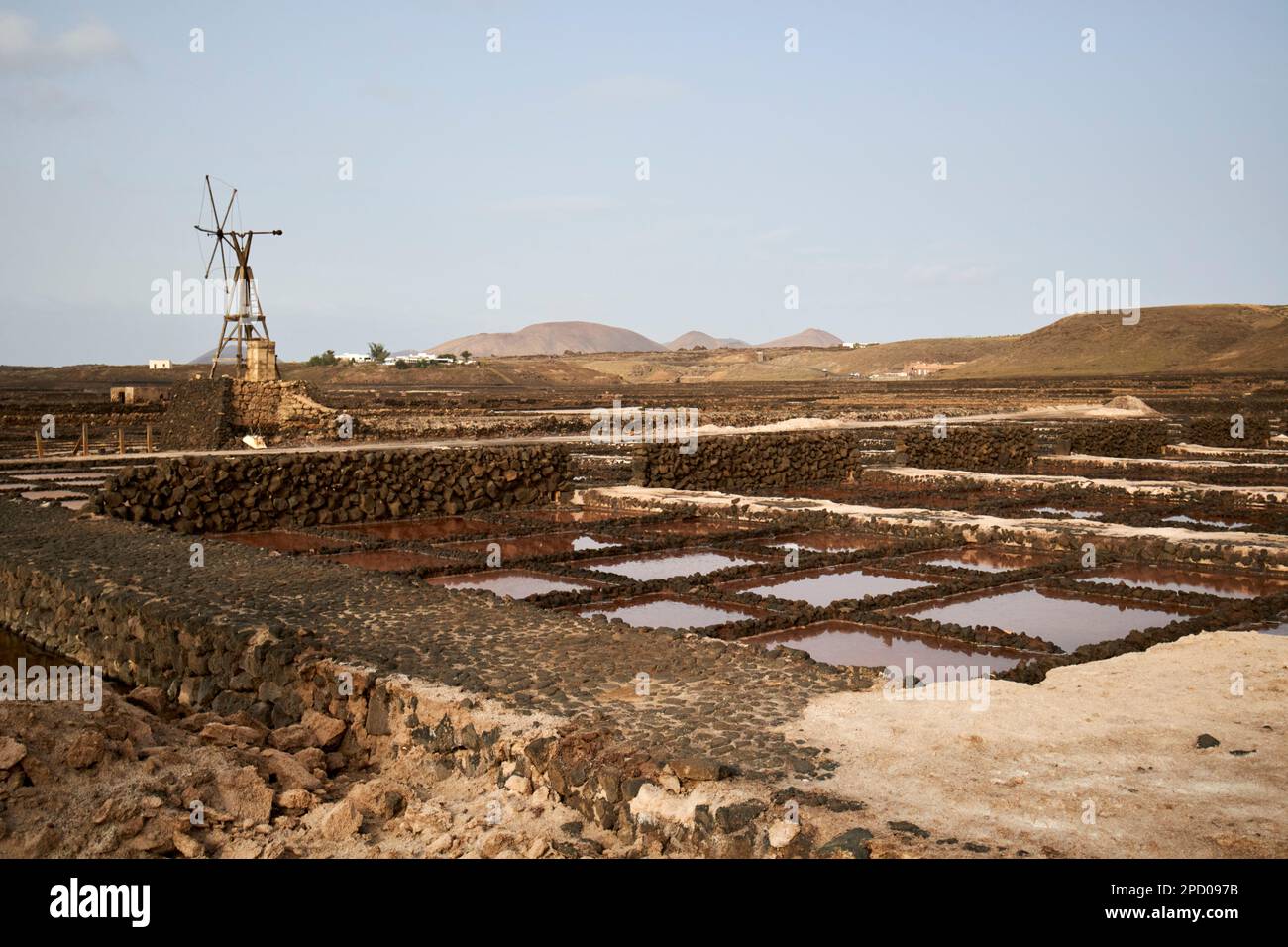 final stage salt water evaporation pools with remains of old wind powered pumping tower salinas de janubio salt flats Lanzarote, Canary Islands, Spain Stock Photo