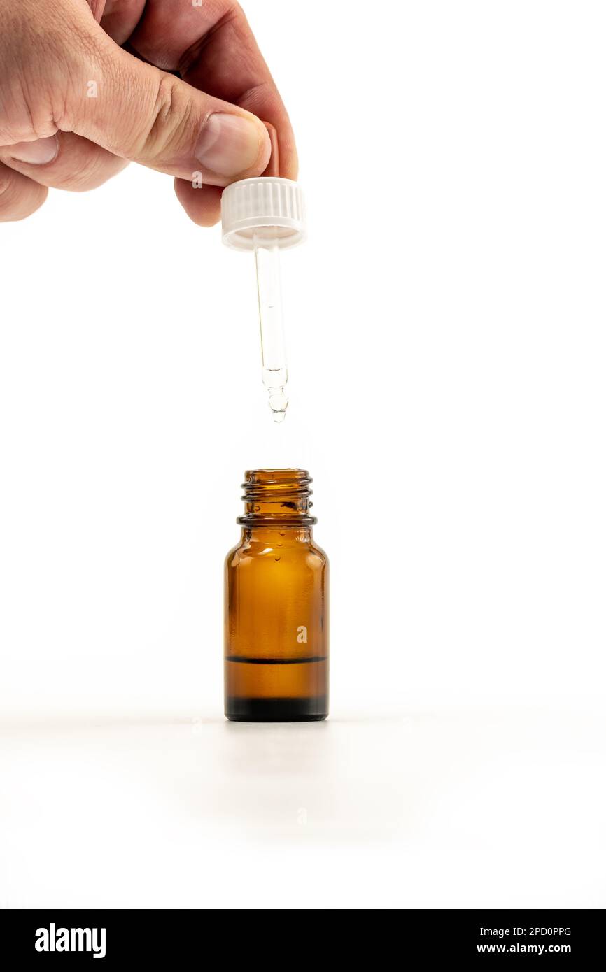 Closeup photo of person dispensing medical drops vertically dripping