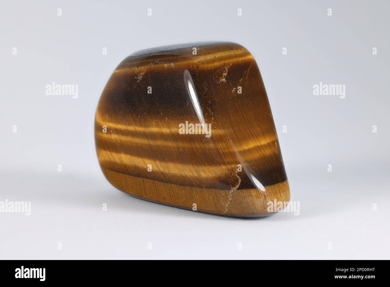 Tiger's eye, also called tiger eye,  is a quartz group gemstone with a golden to red-brown colour and a silky lustre. Stock Photo