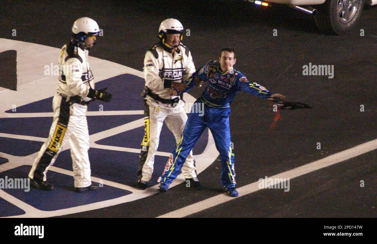 Driver Kyle Busch is restrained by a NASCAR official as Busch throws