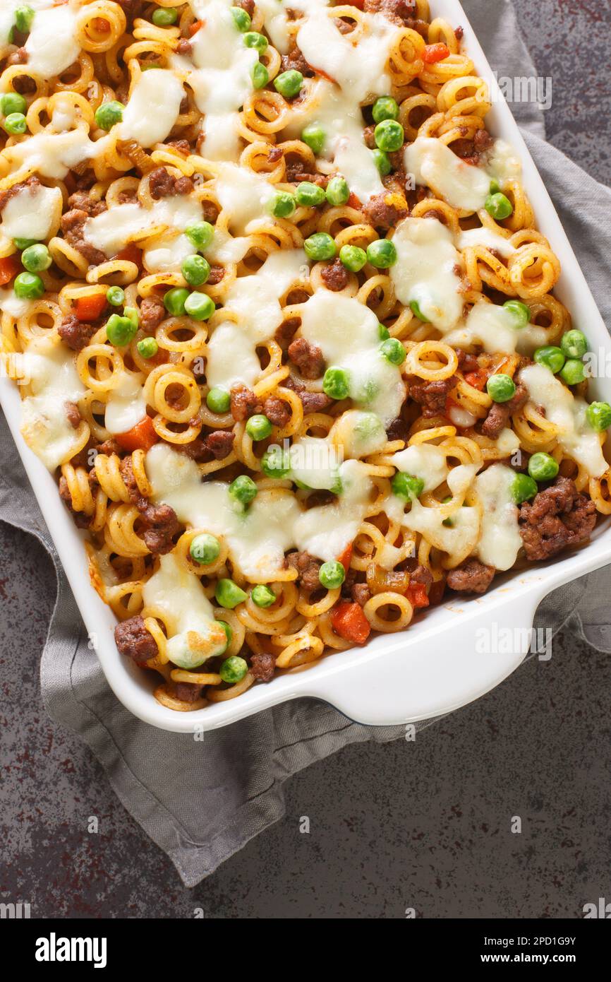 Pasta gratin with cheese, ground beef, vegetables closeup in a baking