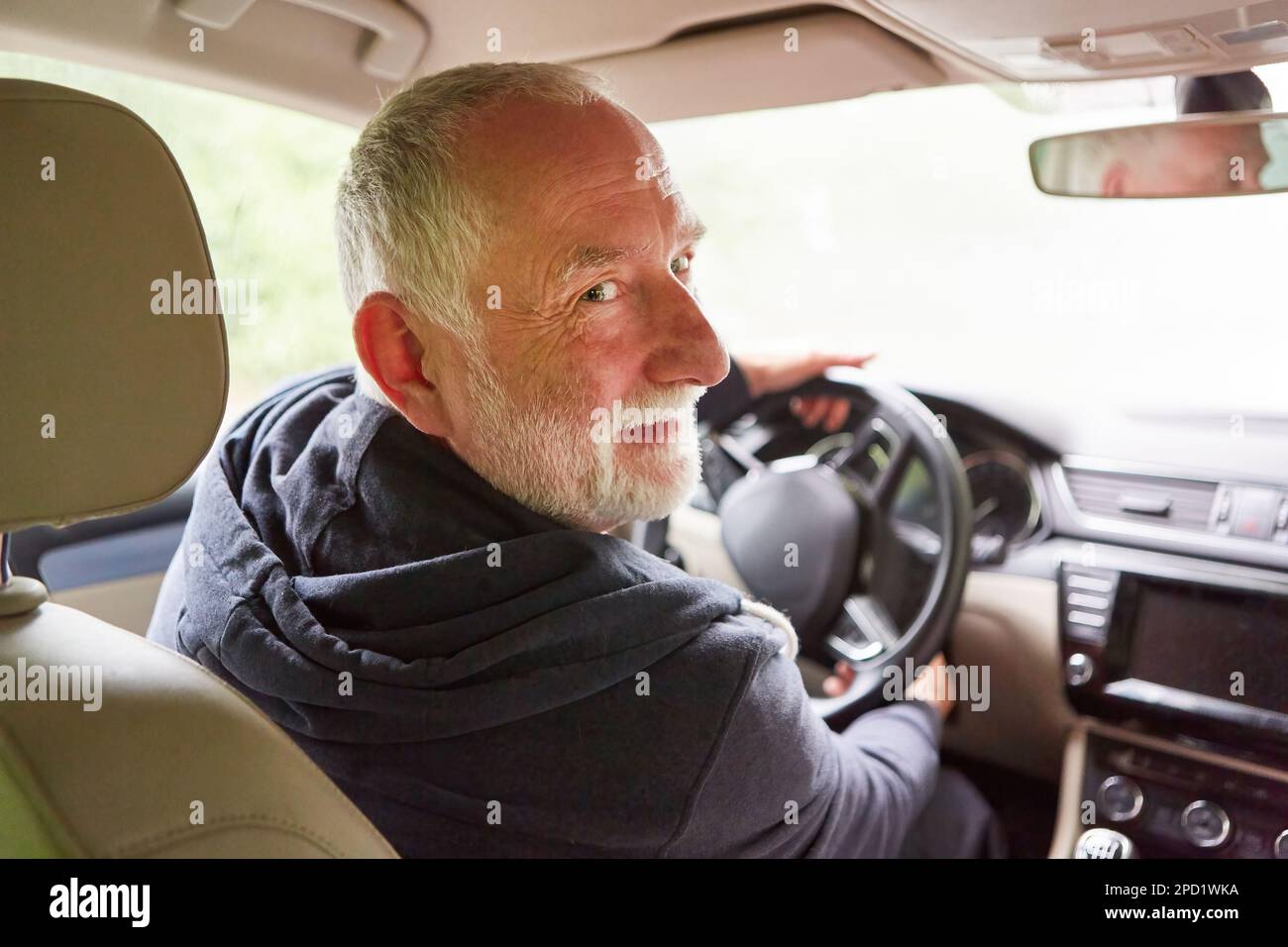 Smiling senior man traveling in car during road trip on vacation Stock Photo
