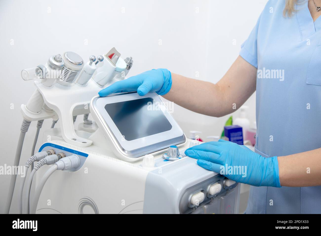 Cropped professional dermatologist setting up and using hydra facial