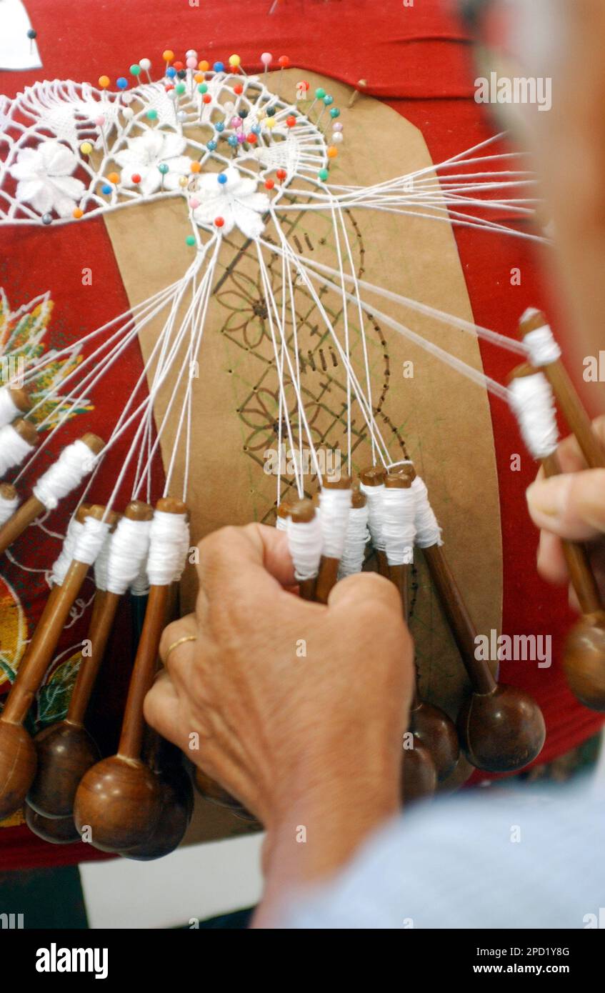 Handmade bobbin lace from northeast Brazil on August 08, 2003. Craftswoman's hands in close-up with blurred background. Brazilian crafts Stock Photo