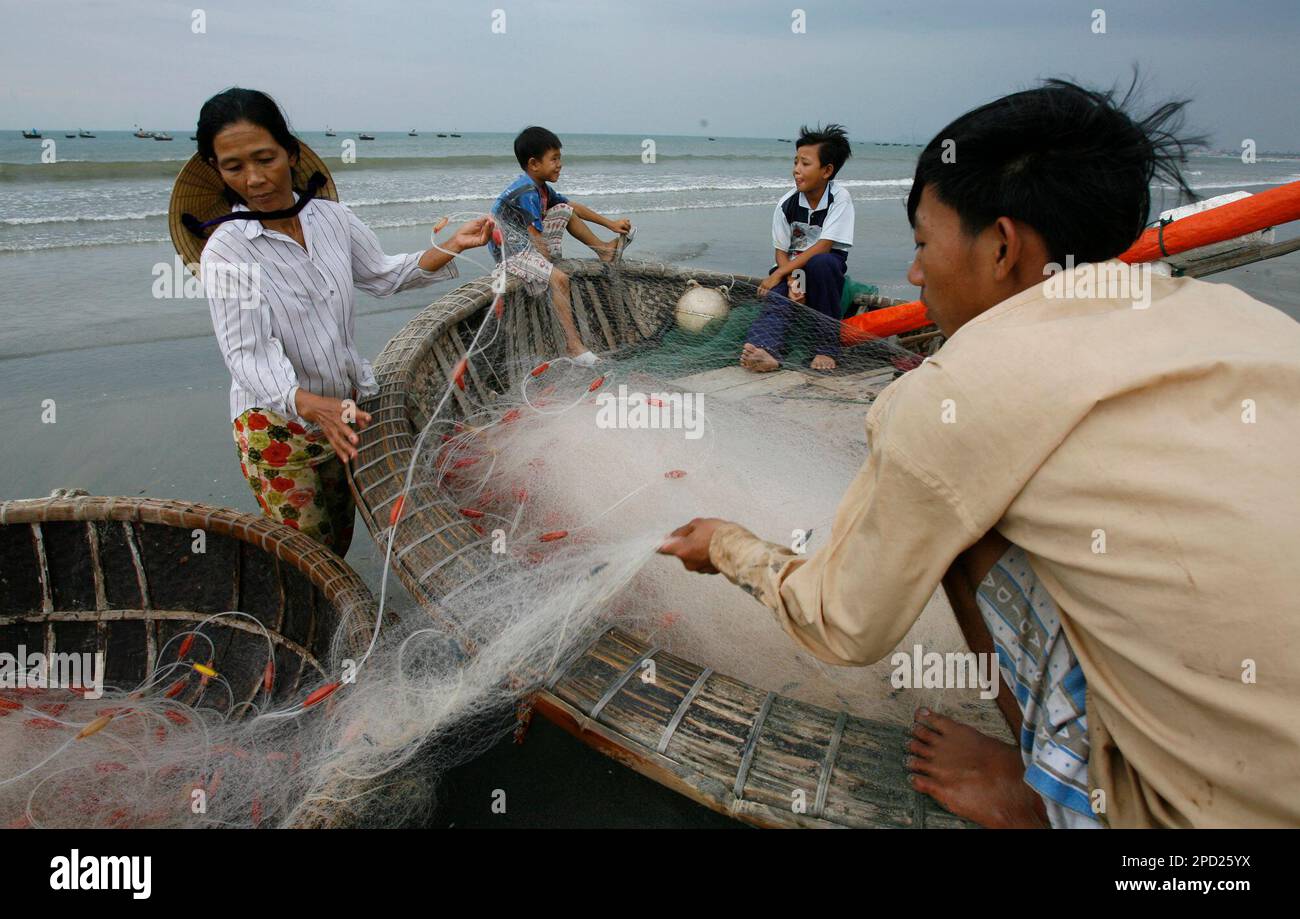 Vietnamese fishermen pack their nets after a day of fishing in Danang ...